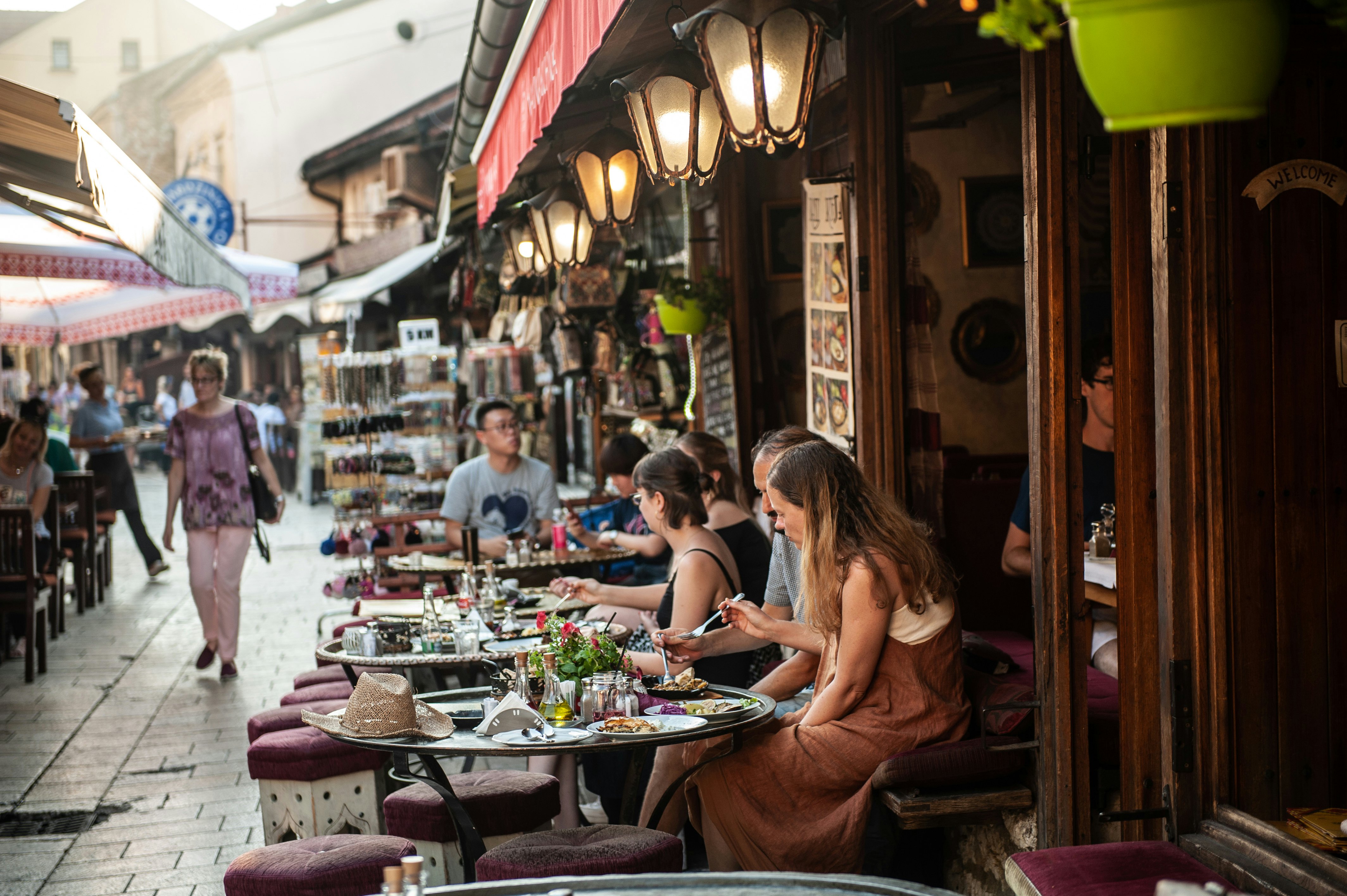 Traditional Bosnian restaurant in the Old Town of Sarajevo with diners sitting outside in a lane, Bosnia and Herzegovina
