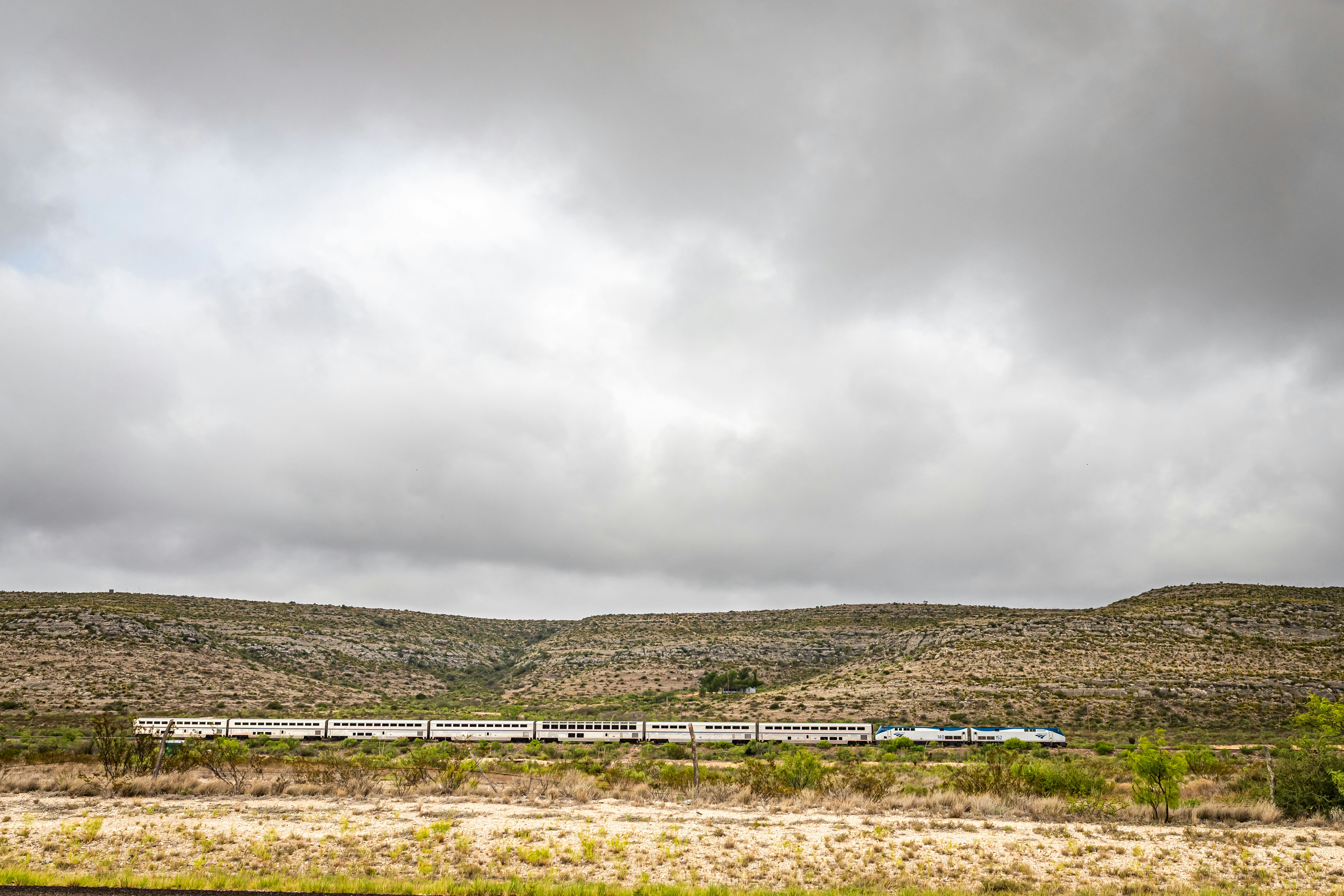 The Amtrak Sunset Limited train travels through the desert under a moody sky near Sanderson, Texas.