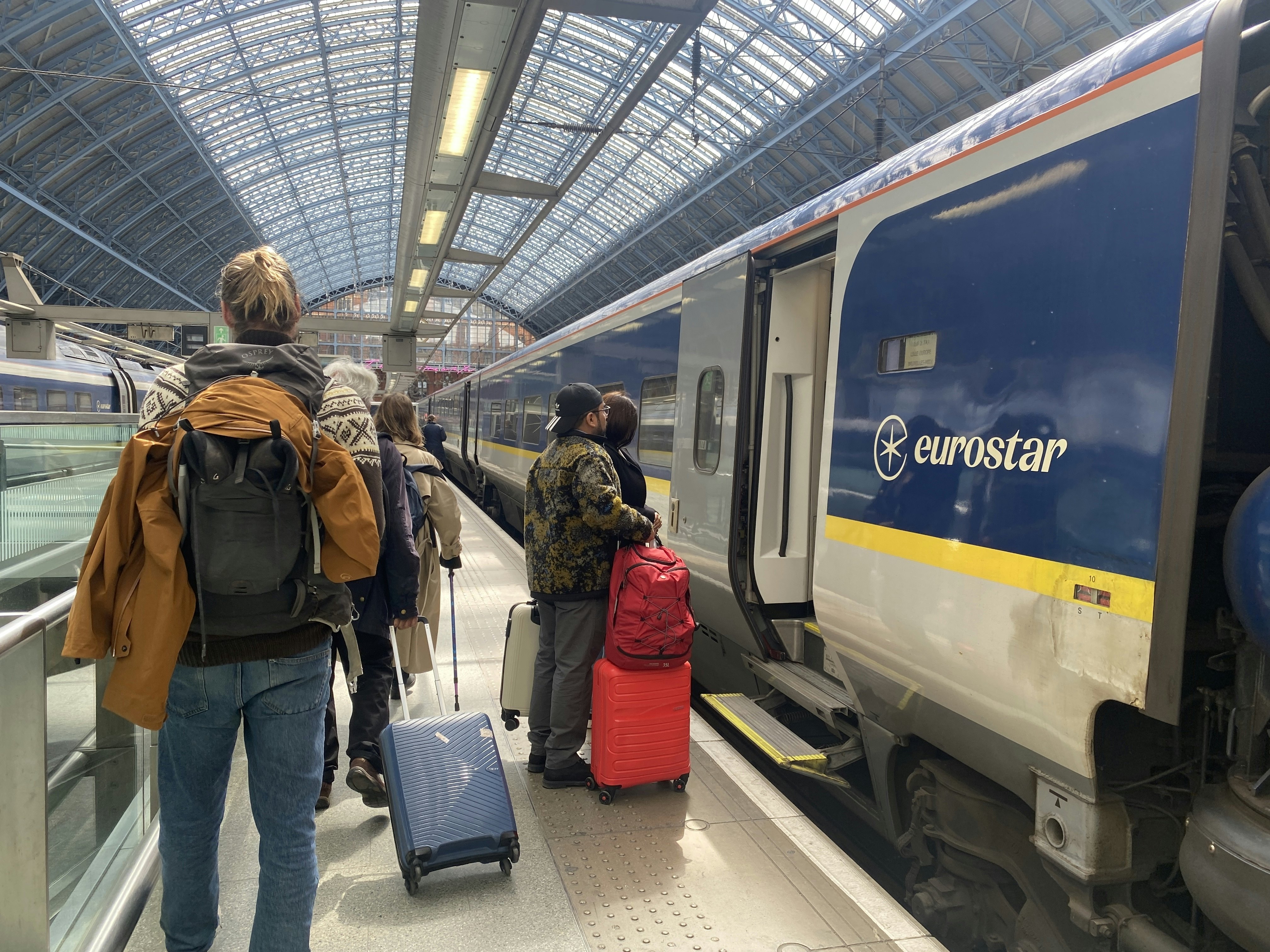 London, England - April 13, 2024: Travelers walk on the platform to board a Eurostar train from London to Paris.