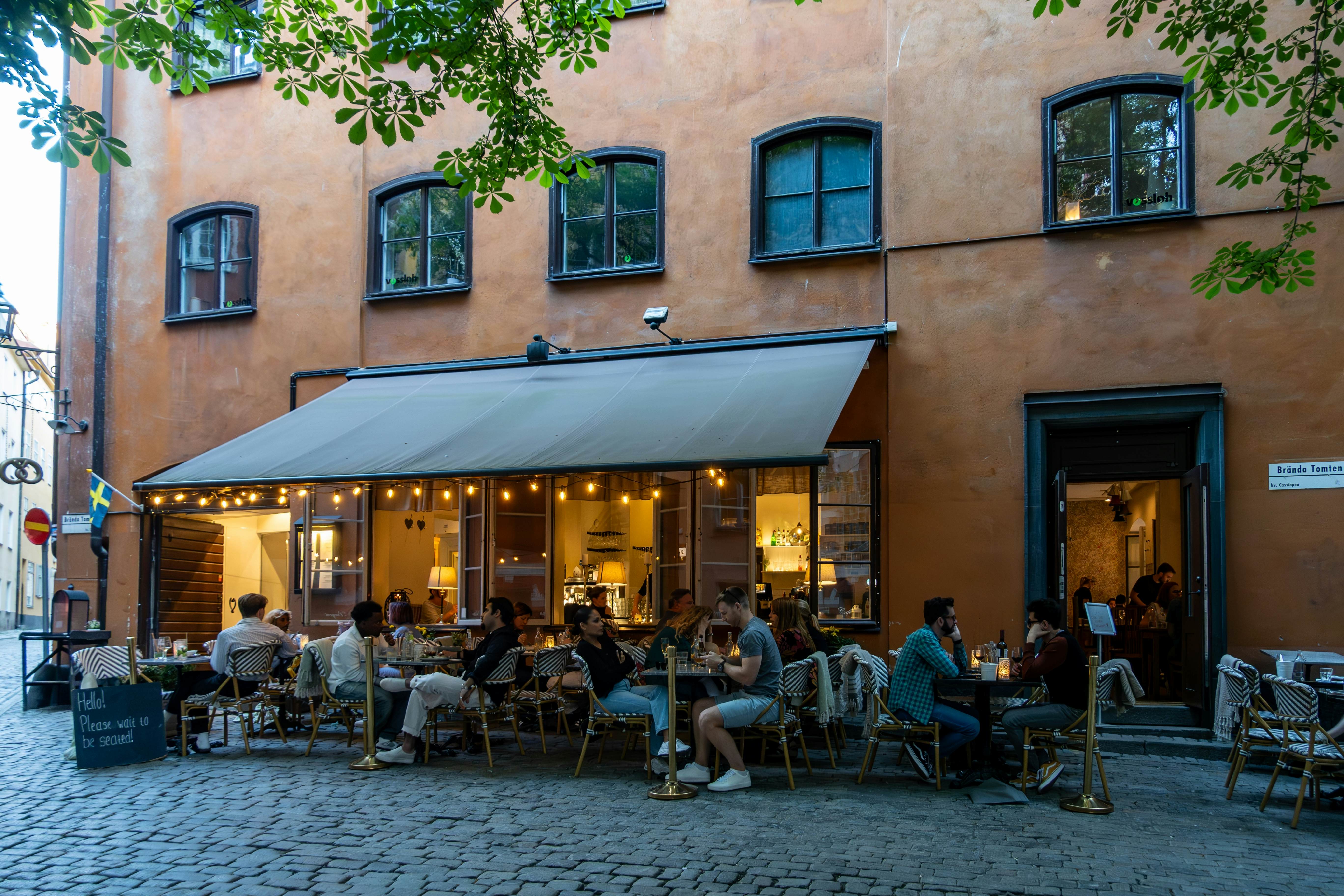 People sitting outdoors at a landmark restaurant called Under the Chestnut Tree, Under Kastanjen in Swedish in Stockholm, Sweden