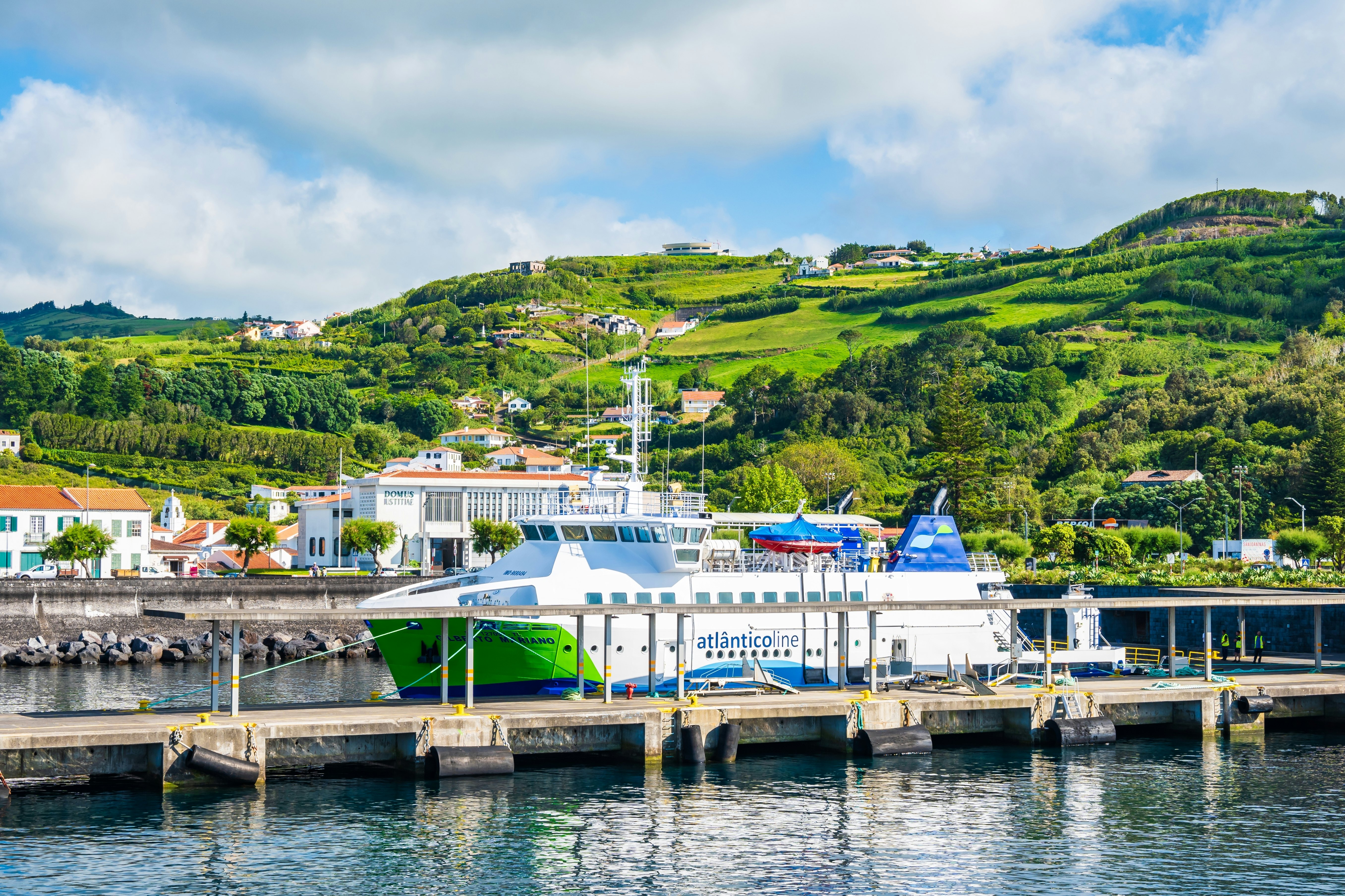 A ferry backed by green hills in the port of Horta on the island of Faial in the Azores.