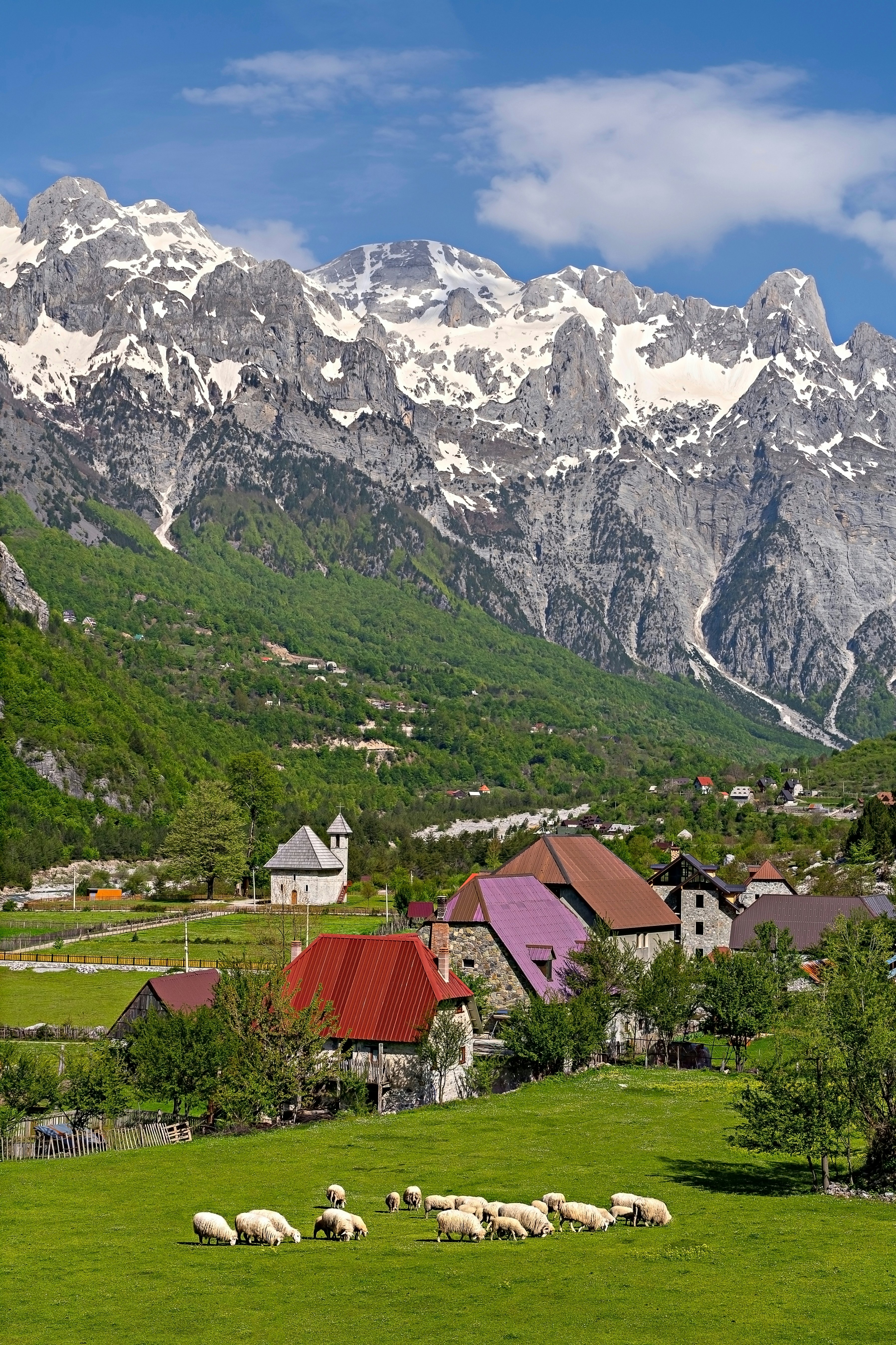 Theth Village with snow capped mountains in the Theth Valley in Albania.