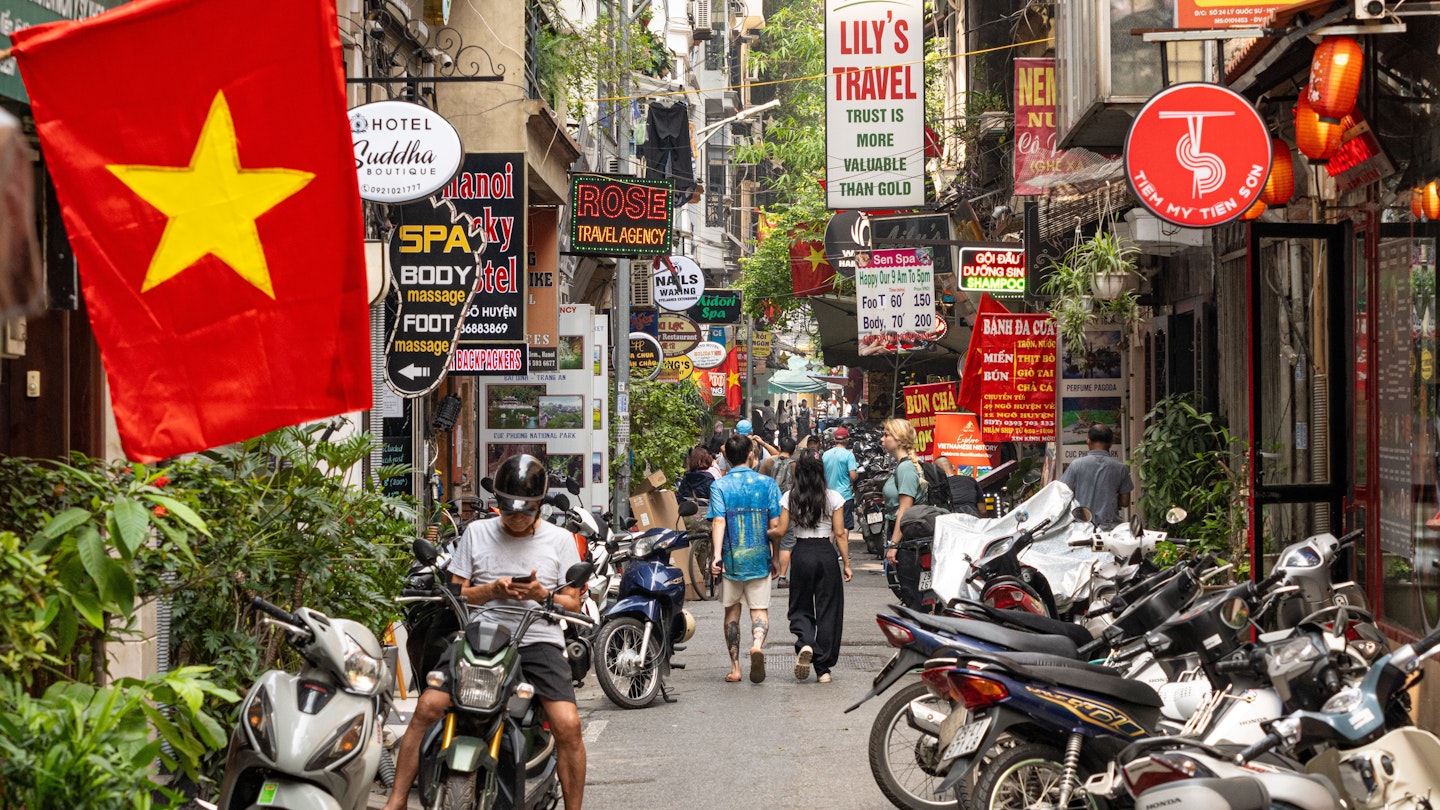 Hanoi Vietnam - April 24 2024: street life in Hanoi City at daytime with the red Hanoi flags and people on the street. The busy streets of in Hanoi with scooters, motorcycles, billboards and tourist. , License Type: media, Download Time: 2025-03-20T04:21:40.000Z, User: claramonitto, Editorial: true, purchase_order: 56530 - Guidebooks, job: Global Publishing-WIP, client: Vietnam 17, other: Clara Monitto