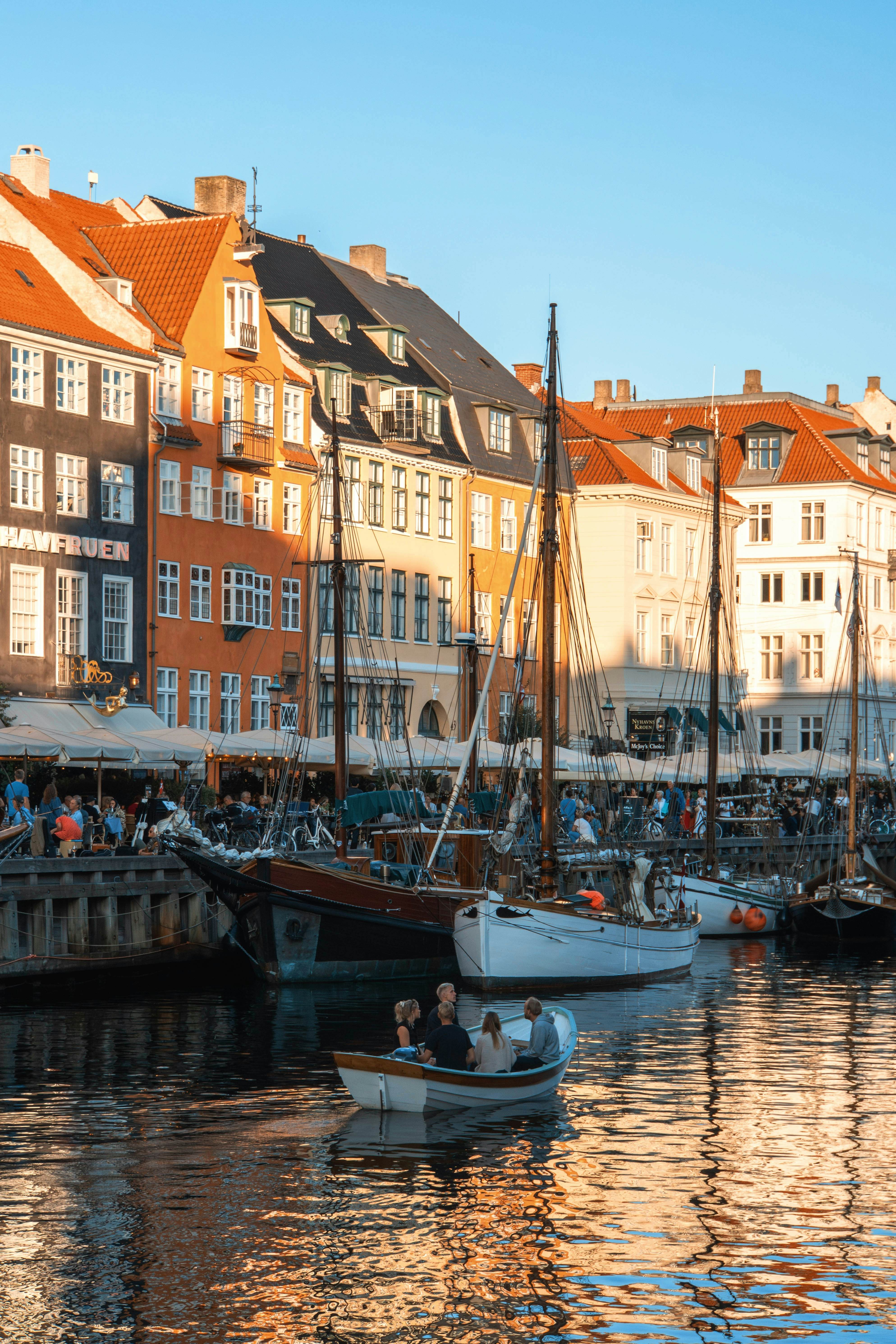 Boats in a harbor with buildings along the side.