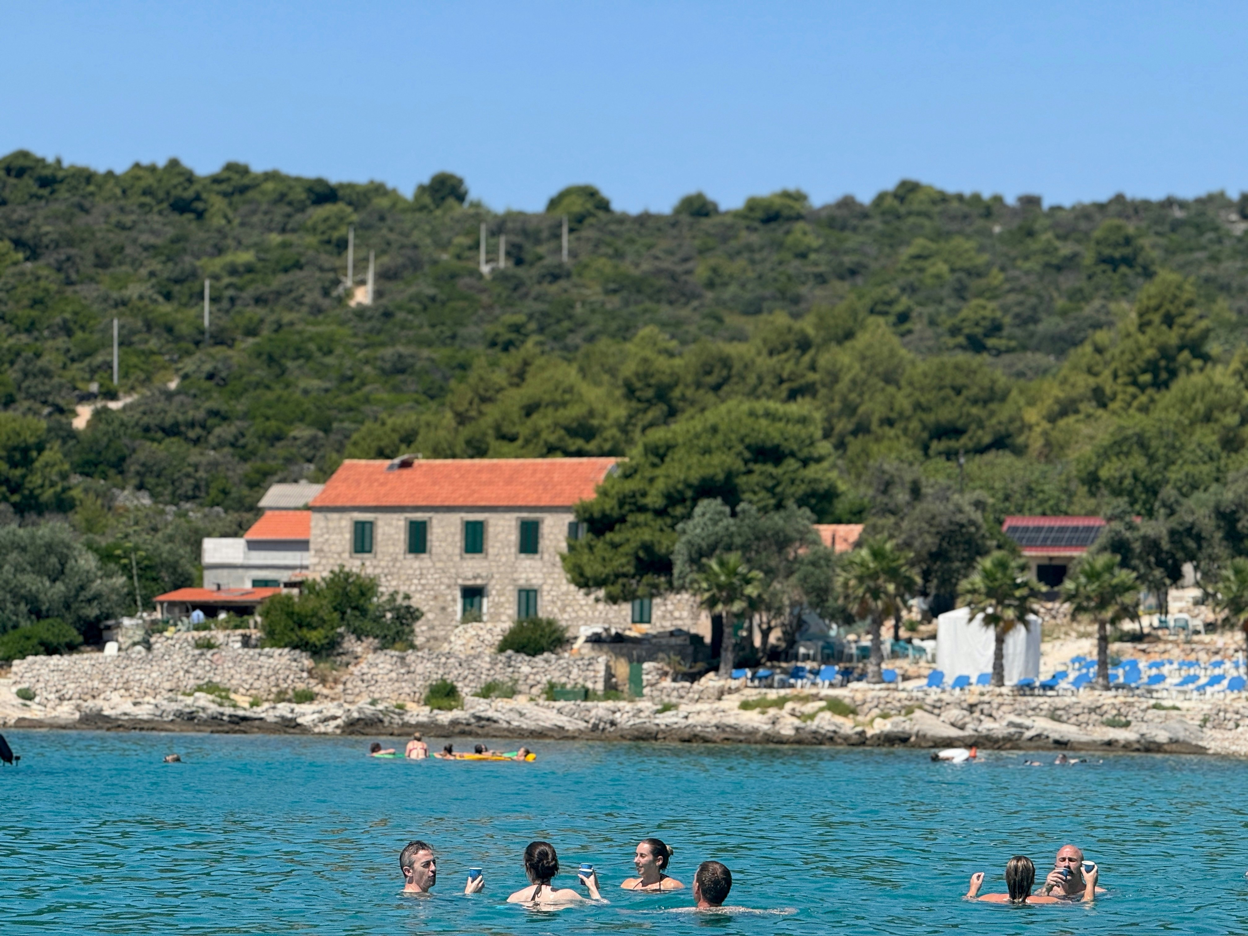 Swimmers float in a lagoon in a small group.