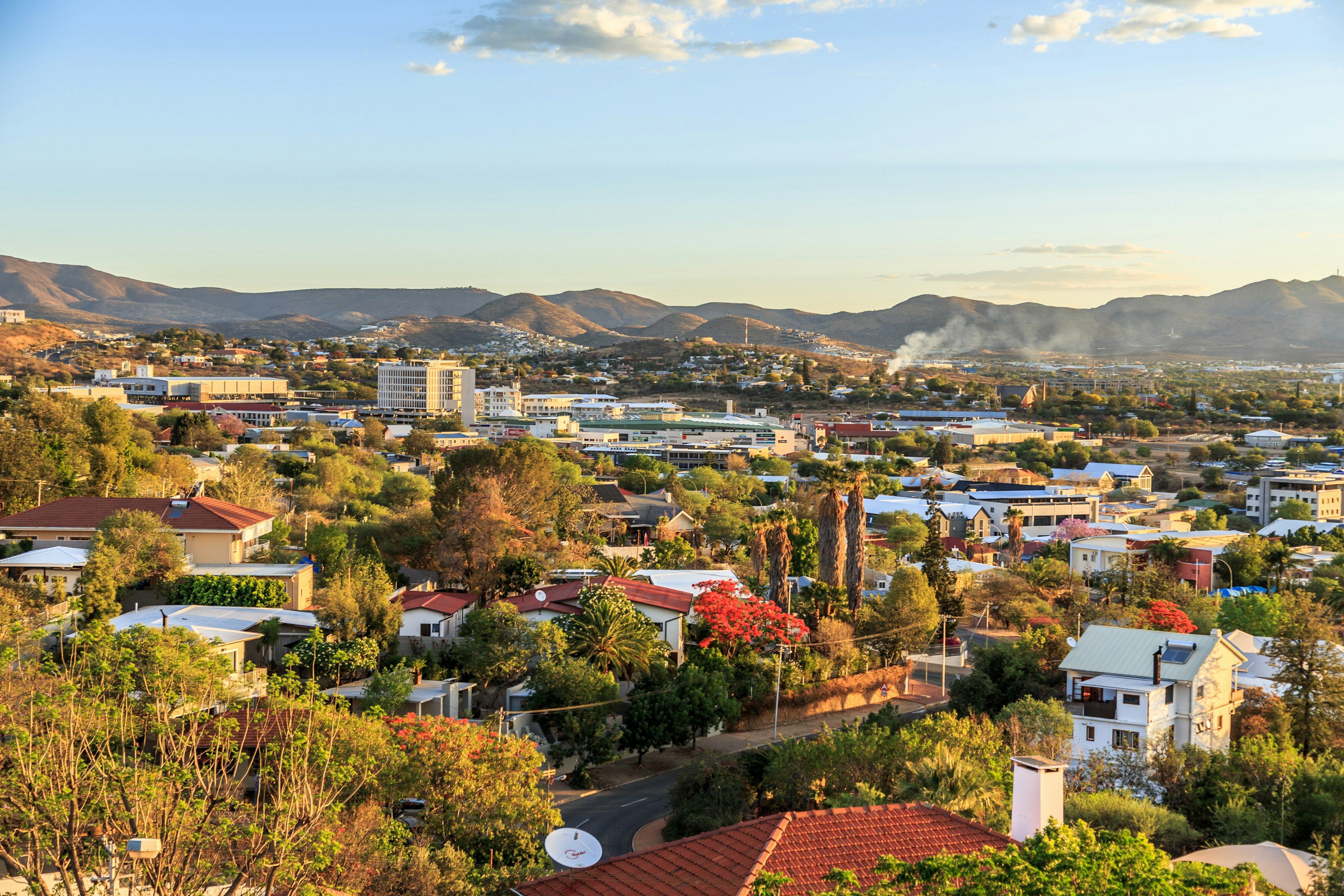 A wide view of a city surrounded by low hills.