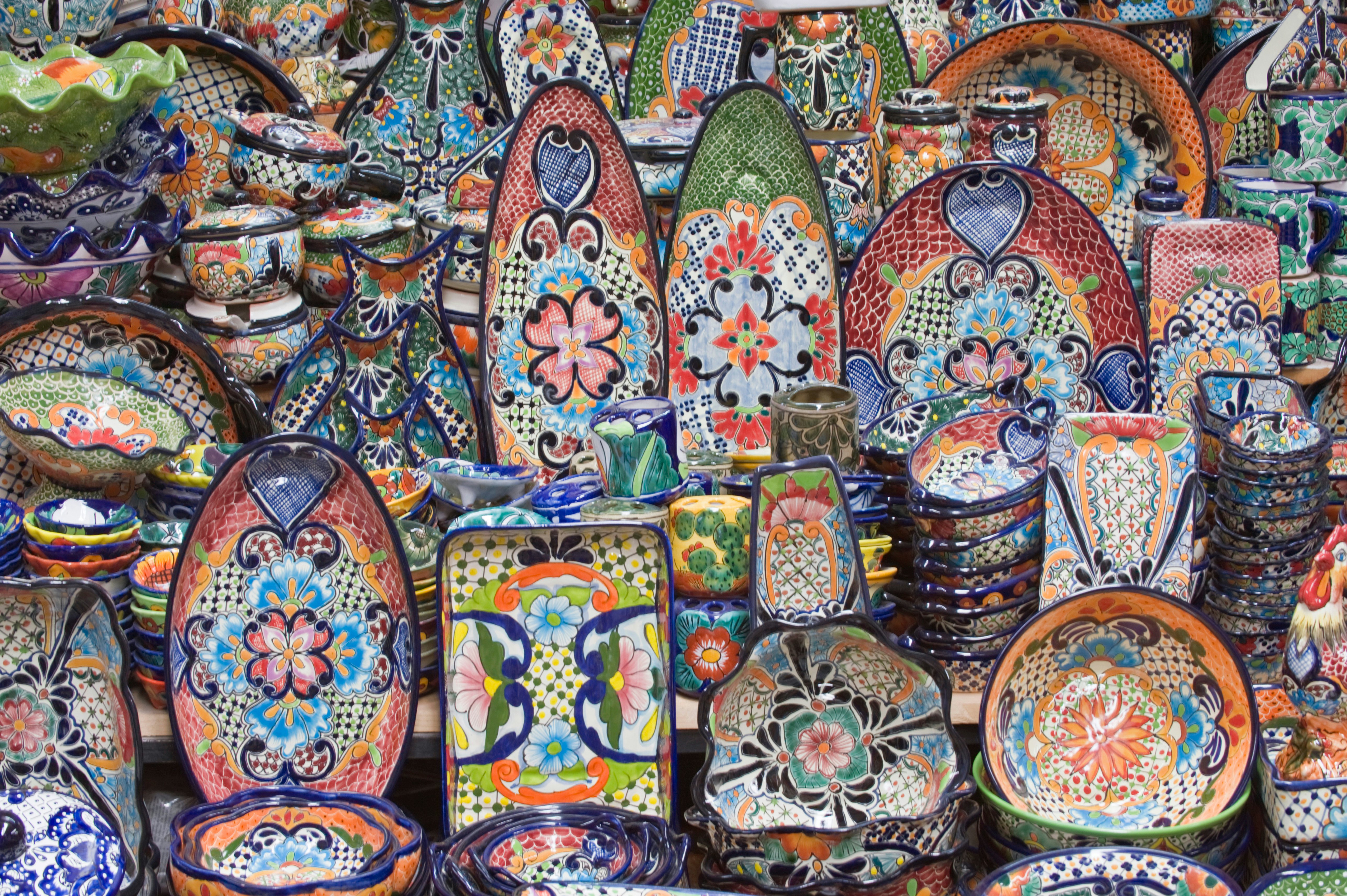 Stacks of pottery bowls and platters in colorful designs.