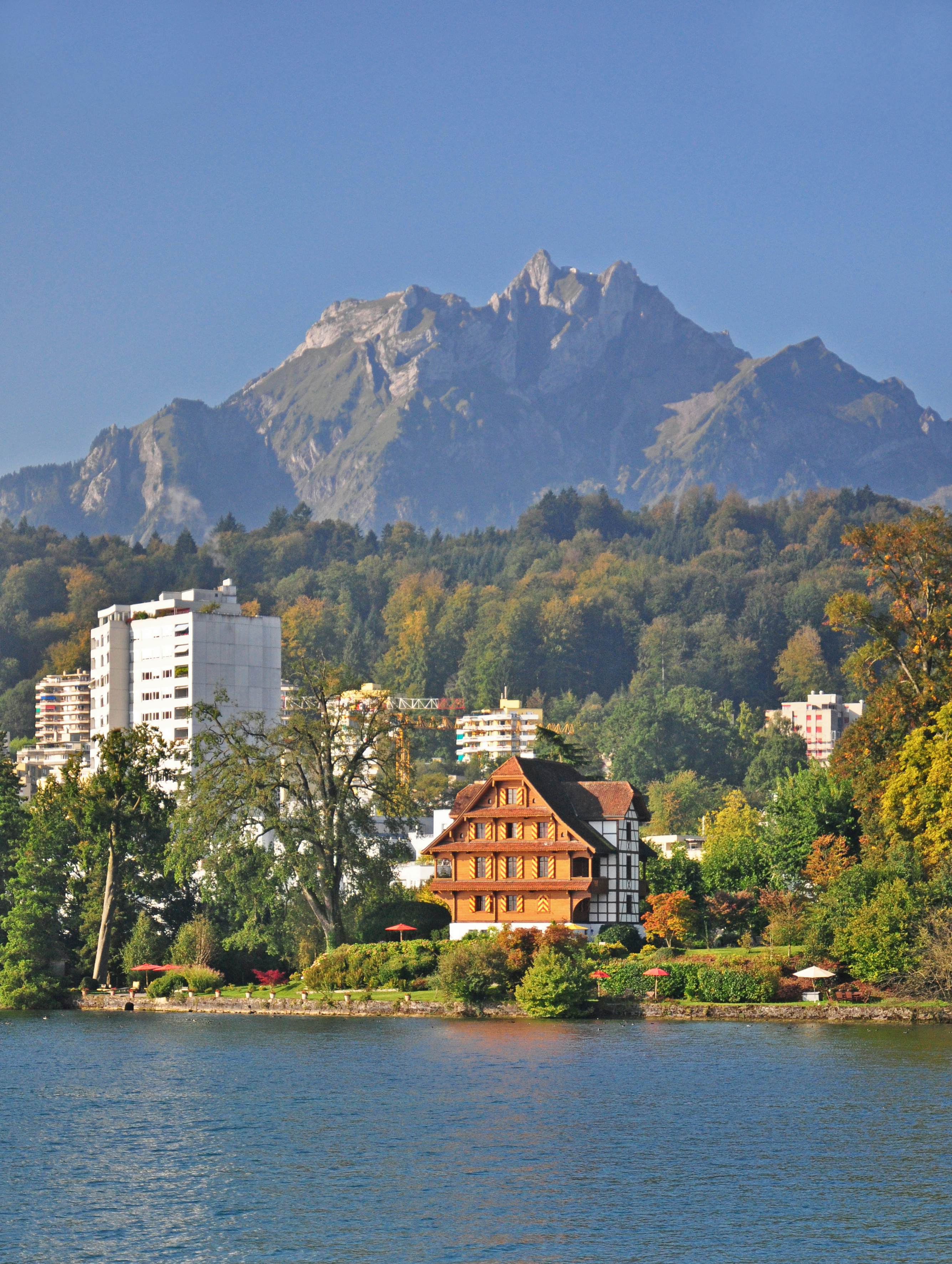 An alpine lake lined with a few buildings among woodland. 