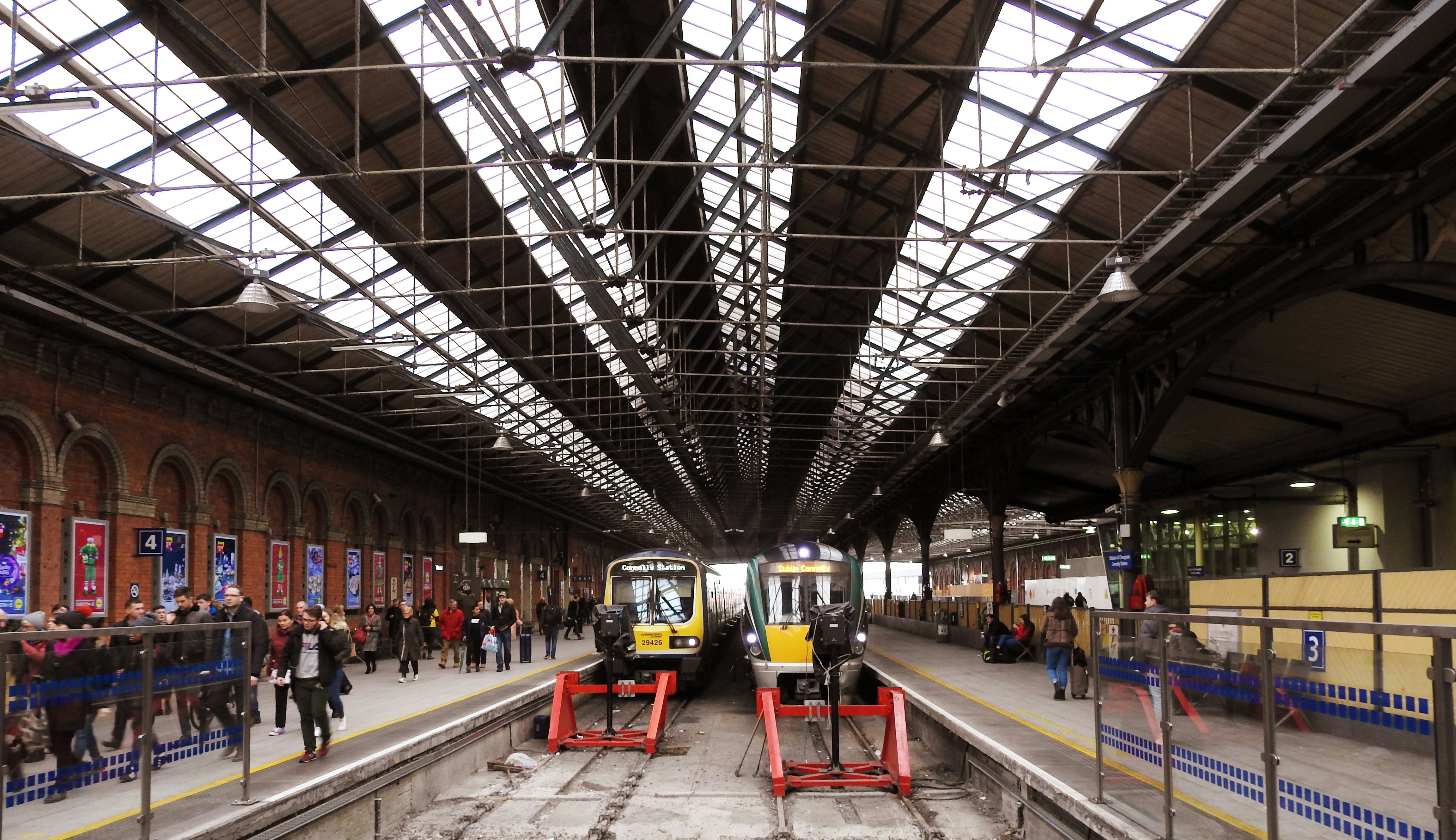 Trains arrive in Dublin's Connolly Train Station with passengers on the platform.