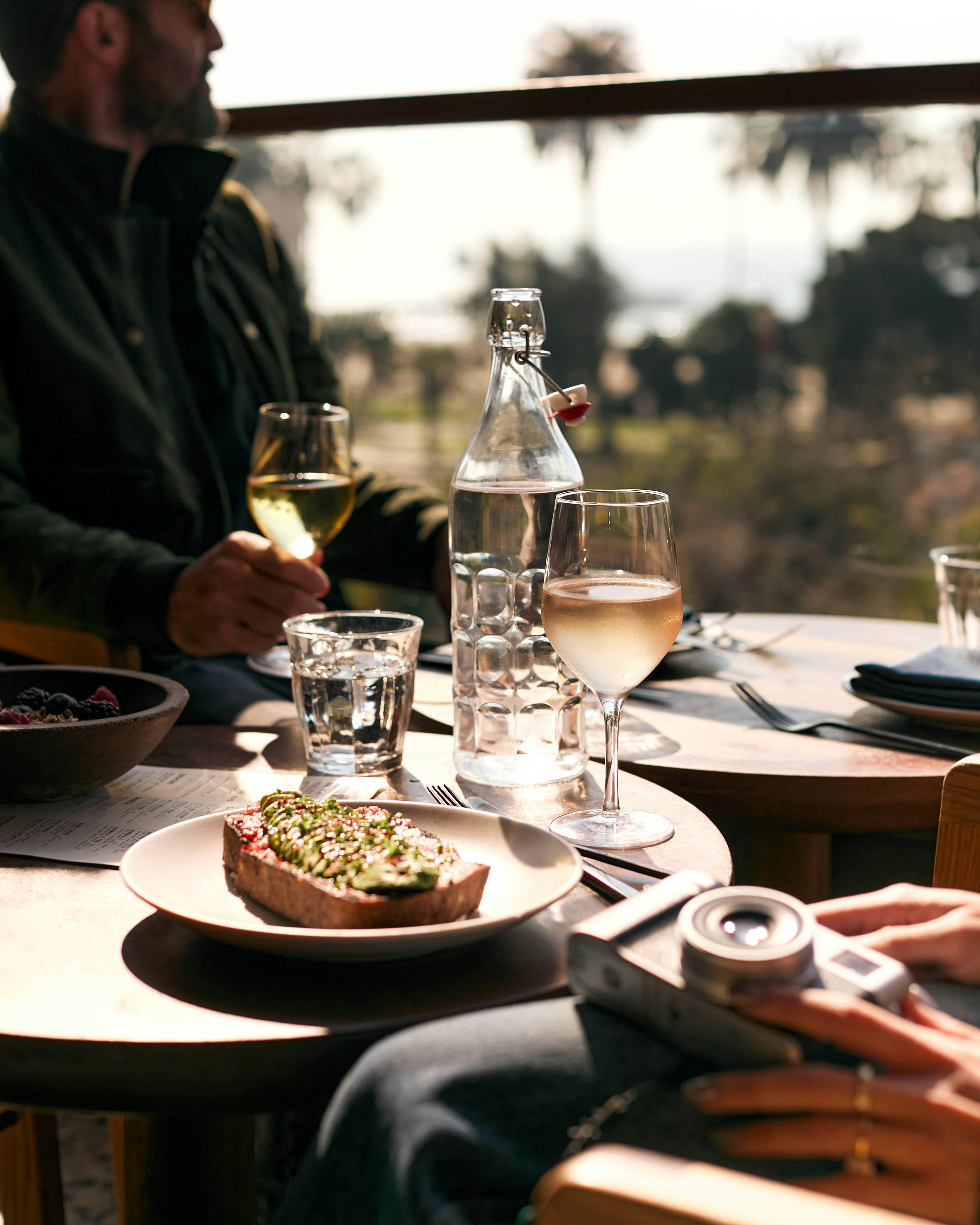 A group of people dining with views of palm trees in the background.