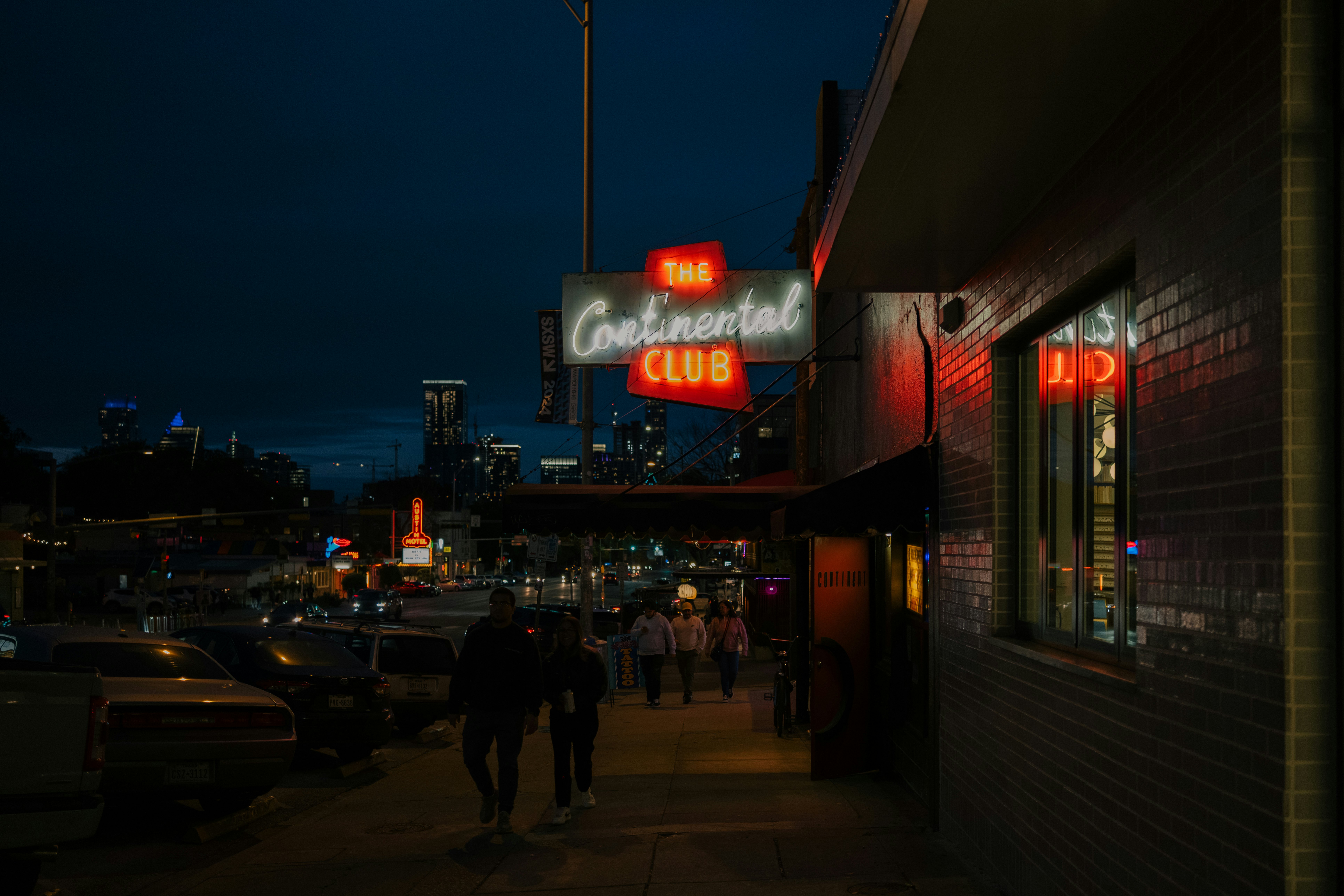 A neon sign glows at night; it reads "The Continental Club."