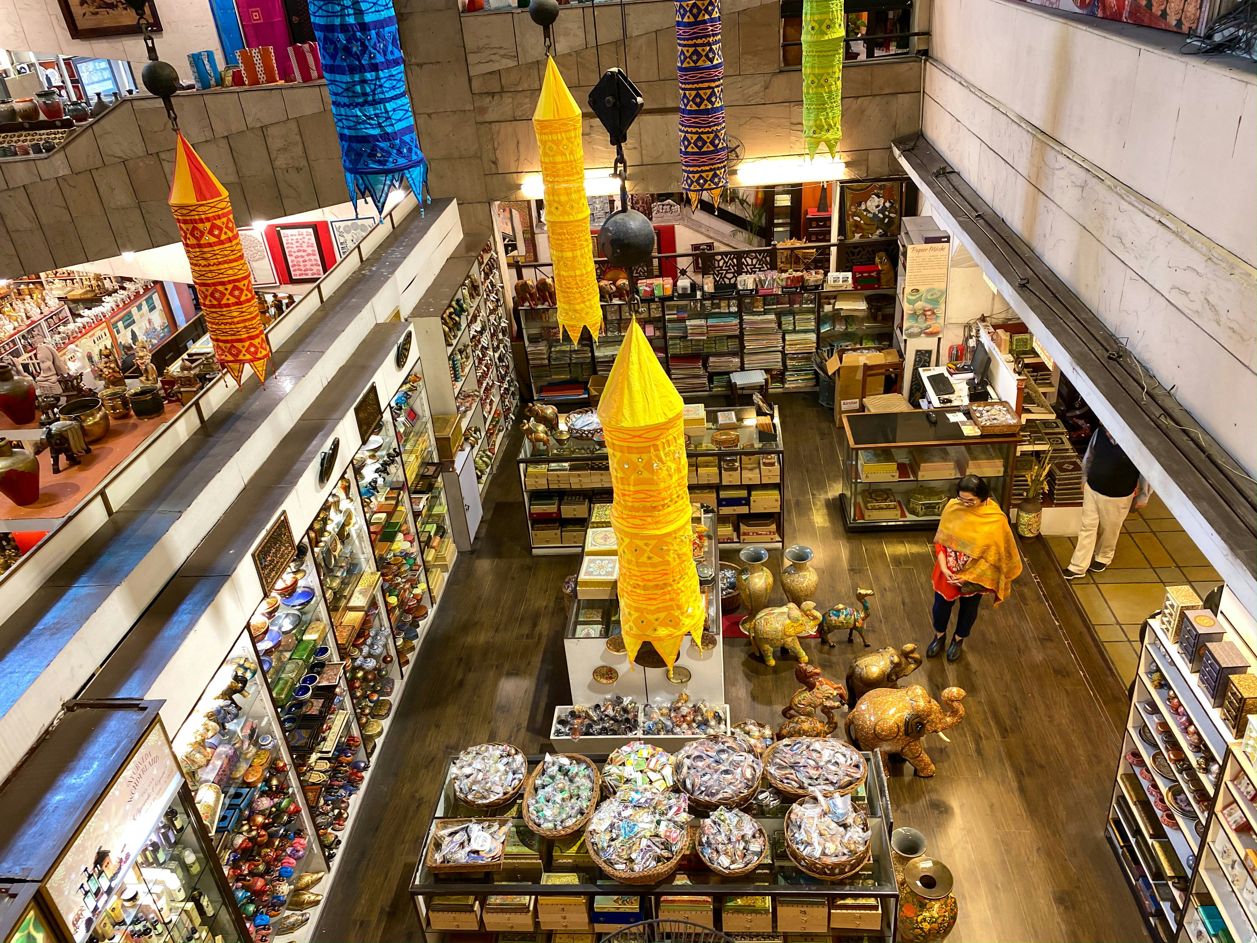 A craft shop with displays of goods for sale including small trinkets and larger vases and elephant-shaped ornaments.