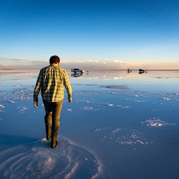 Man Exploring the Shallow Water of Salar de Uyuni Bolivia Creating a Stunning Natural Mirror Effect That Blends the Sky and the Ground into a Perfect Reflection, License Type: media, Download Time: 2025-05-22T14:24:55.000Z, User: lonelyplanetmedia, Editorial: false, purchase_order: 65050 - Digital Destinations and Articles, job: Global Publishing WIP, client: Global Publishing WIP, other: Pia Peterson Haggarty // SS Comp Ingestion