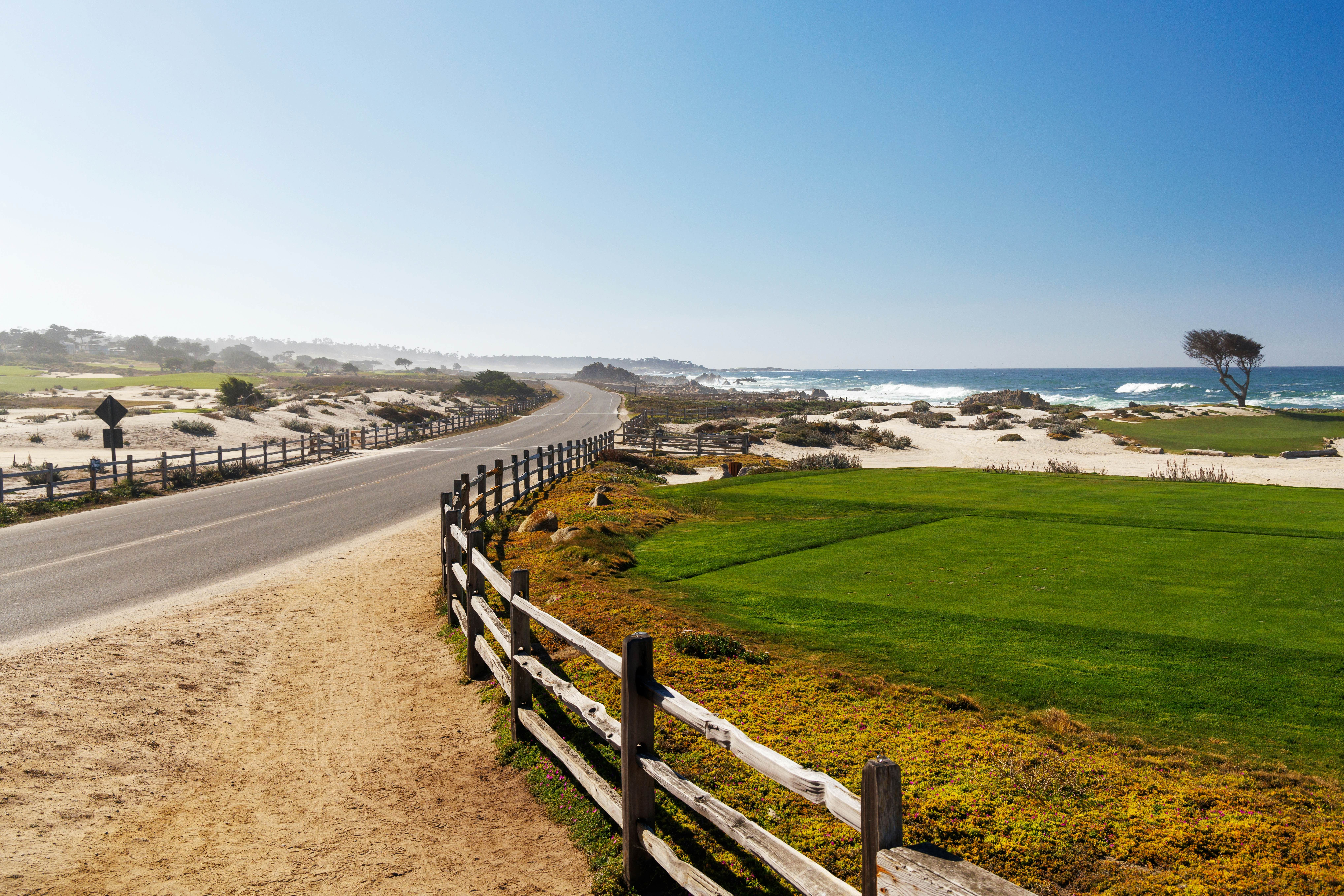 Scenic view of California 17-Mile Drive on a sunny day with ocean, road, and golf courses