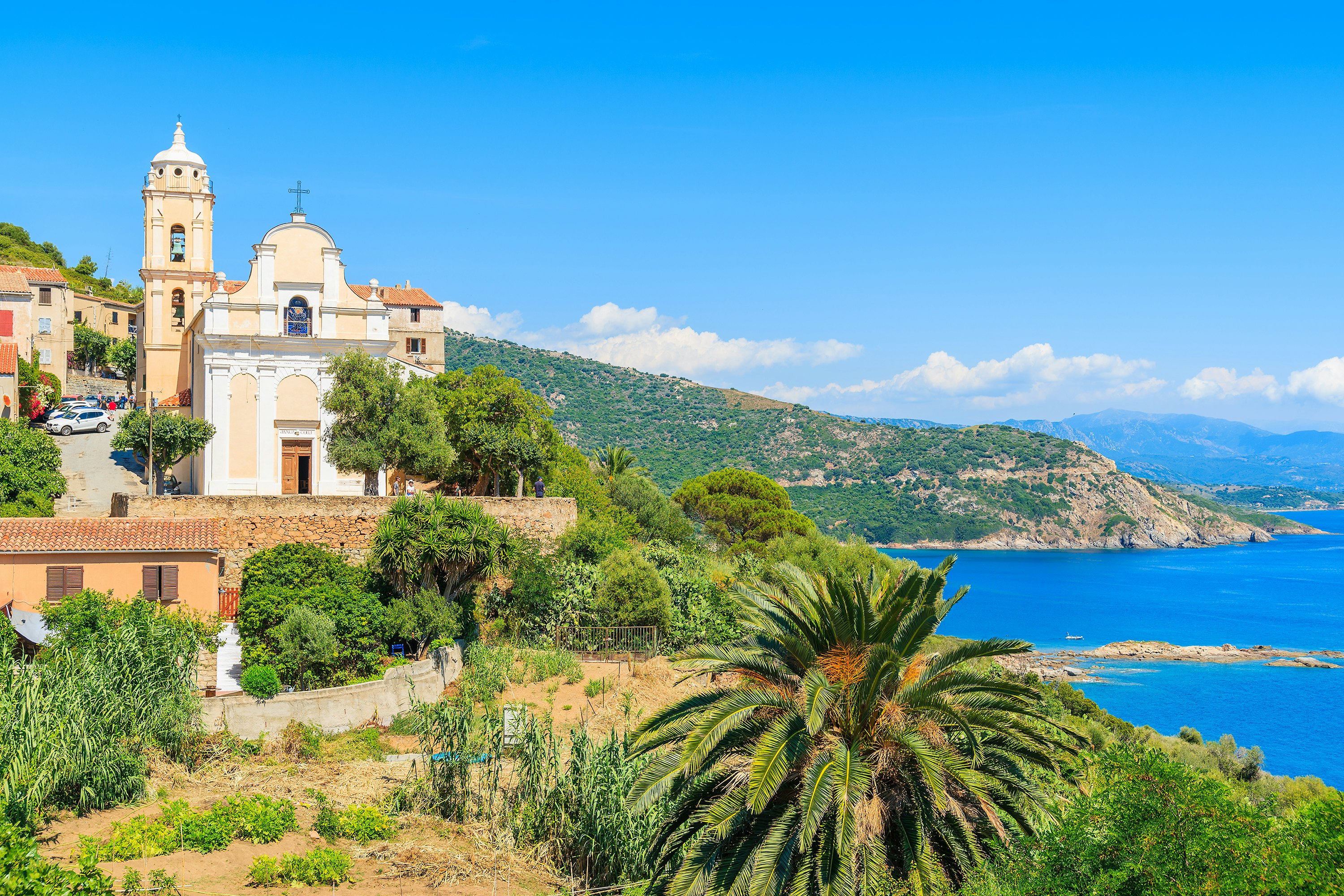 A church and sea cliffs in Cargèse village on the coast of Corsica, France.