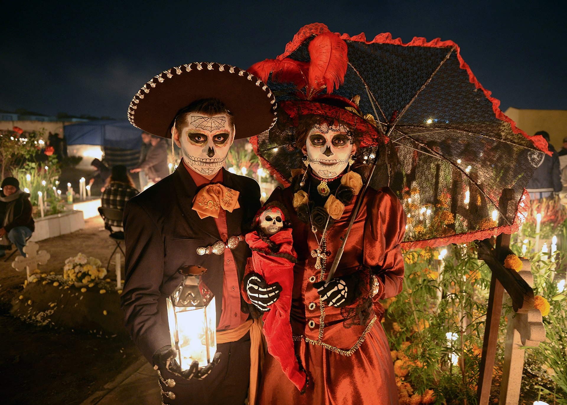 A couple in costume celebrating Mexico's Día de Muertos in a cemetery © MARIO VAZQUEZ / Getty Images