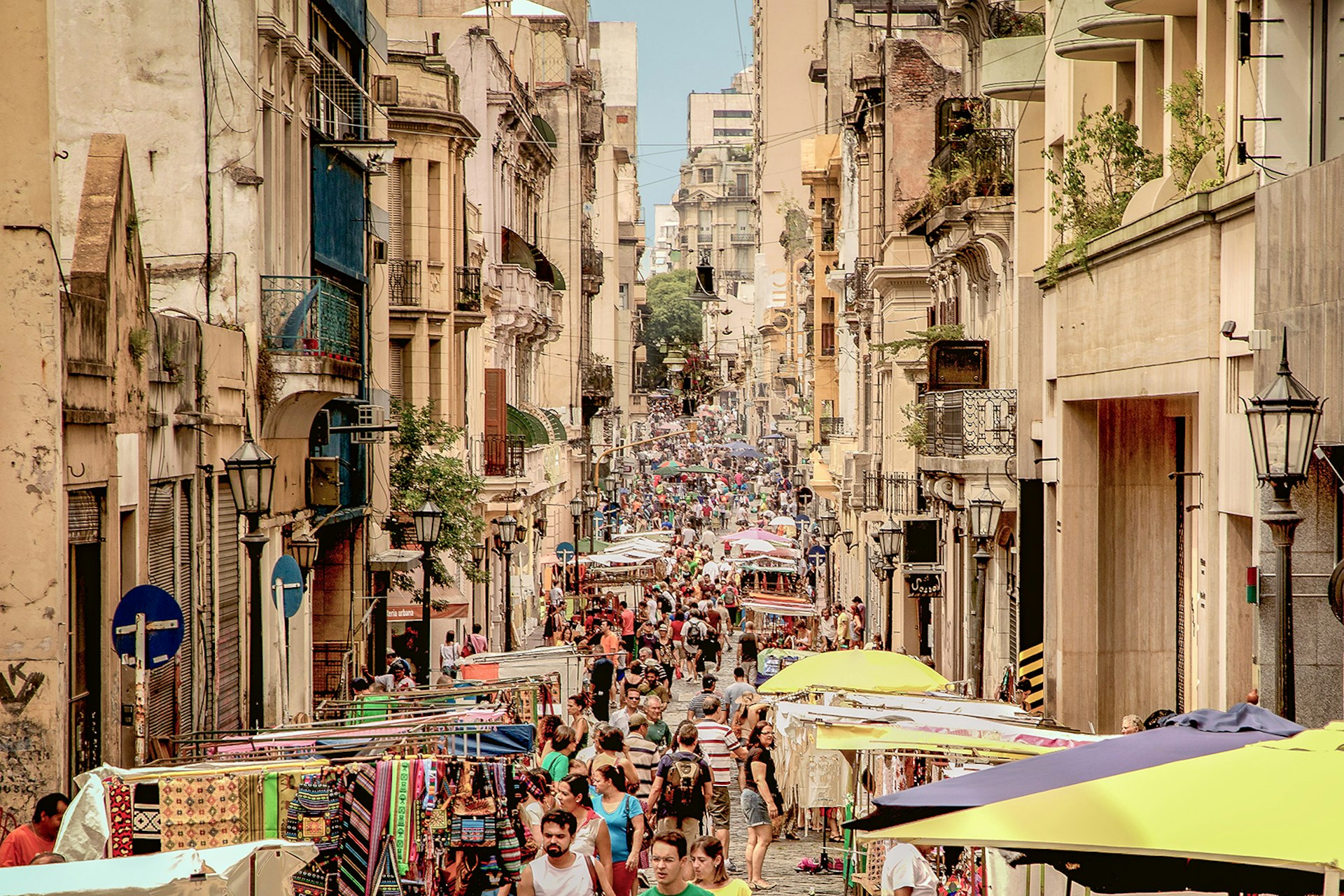 A view down the center of a crowded, stall-lined street in Buenos Aires, Argentina