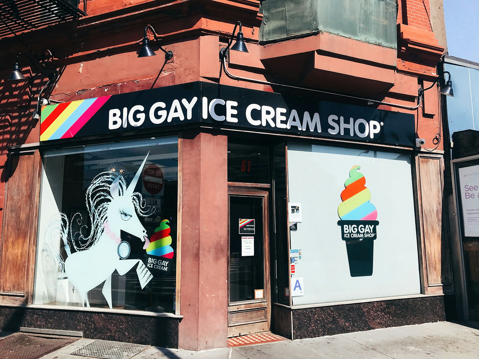 Exterior shot of Big Gay Ice Cream Shop in New York City, with a rainbow cone and a unicorn painted on the facade; ways to enjoy New York City in the summer