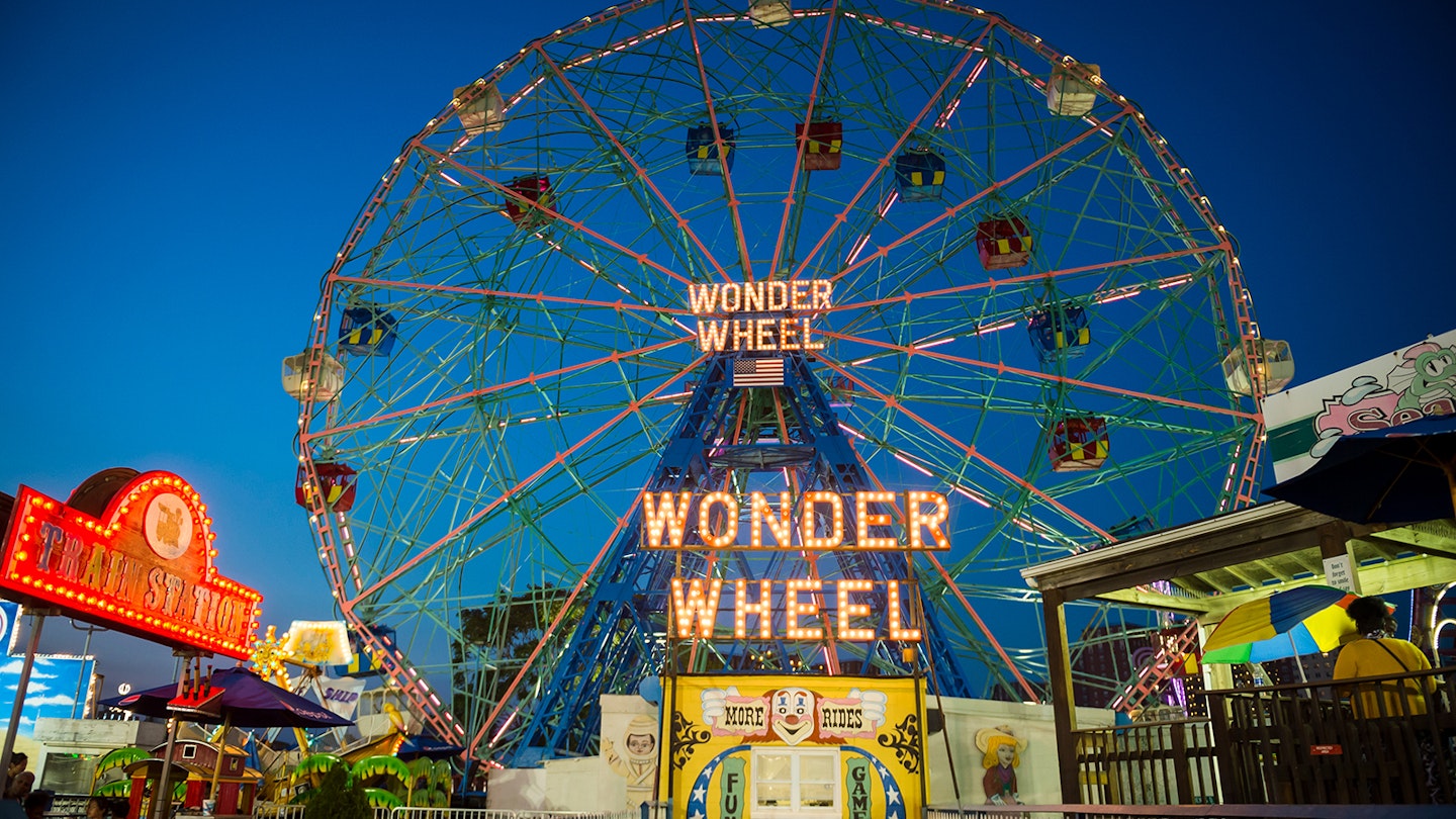 The wonder wheel Ferris Wheel is lit up over Coney Island amusement park in New York at night © lazyllama / shutterstock
