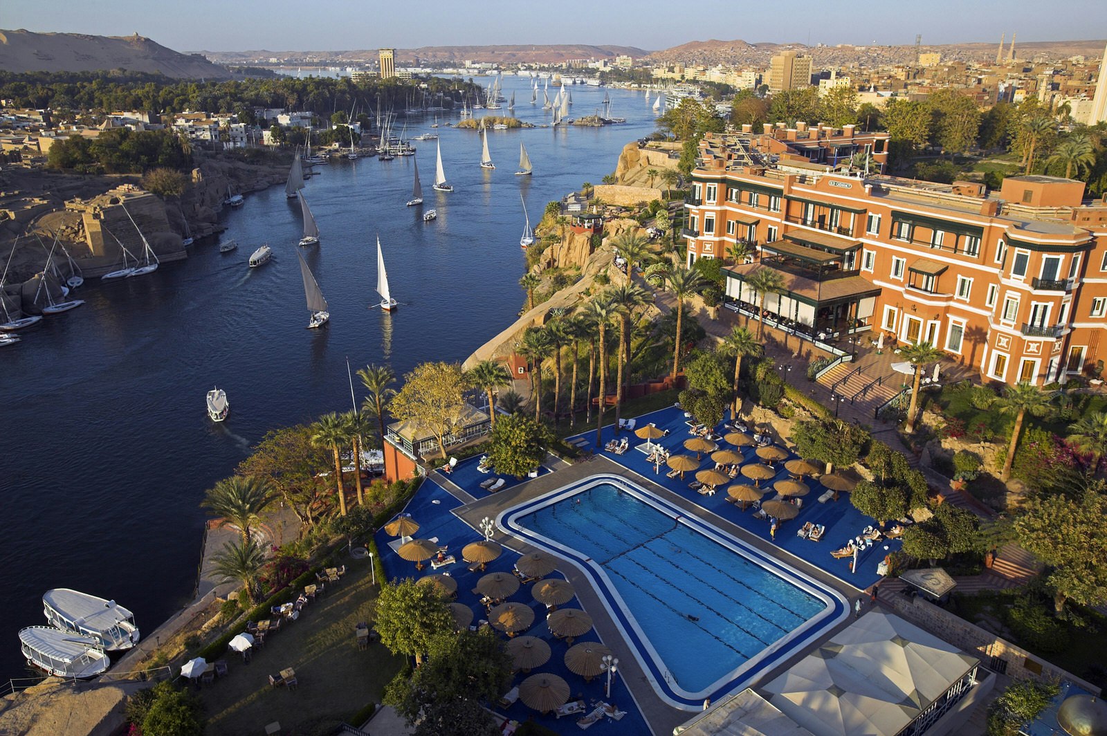 View across the Nile at Aswan in the late afternoon. In the foreground is the Old Cataract Hotel, made famous when Agatha Christie wrote Death on the Nile while staying there. Image by Julian Love / Getty Images