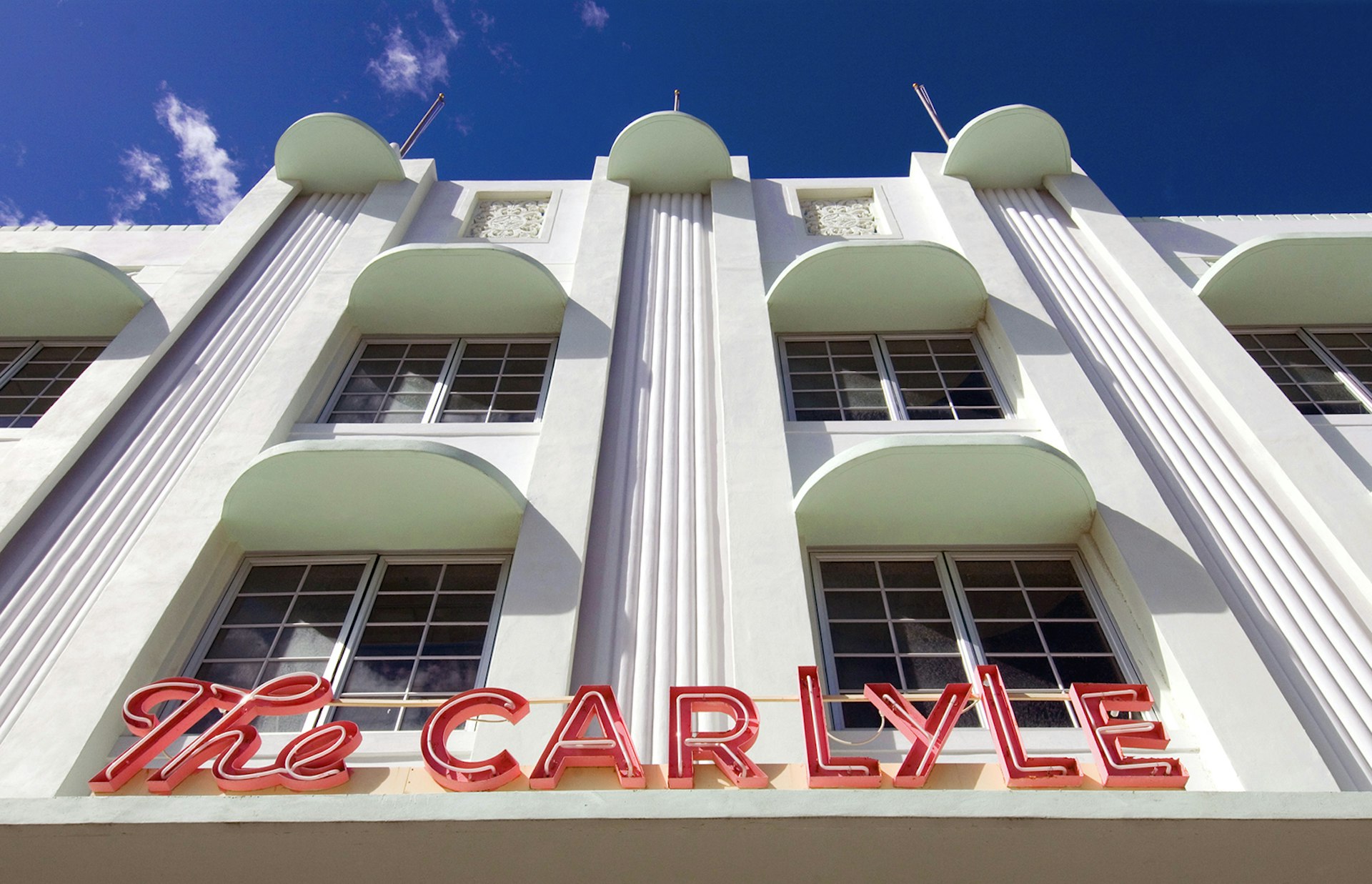 facade of the Carlyle, an art deco hotel in Miami, on a sunny day