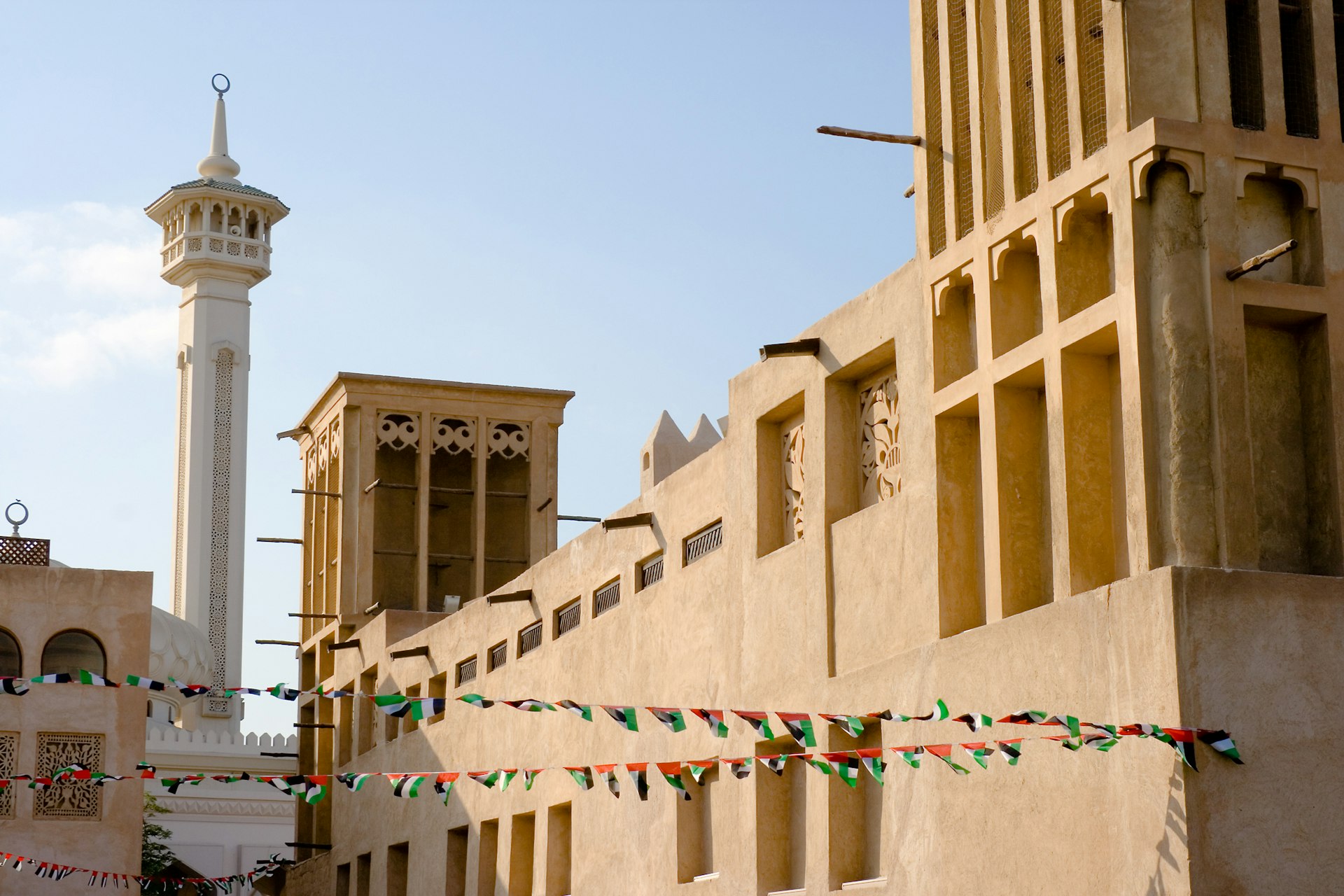 Bastakiya, the old town area of Dubai, with decorative flags on UAE national day. Image by AliquisNJ / Getty
