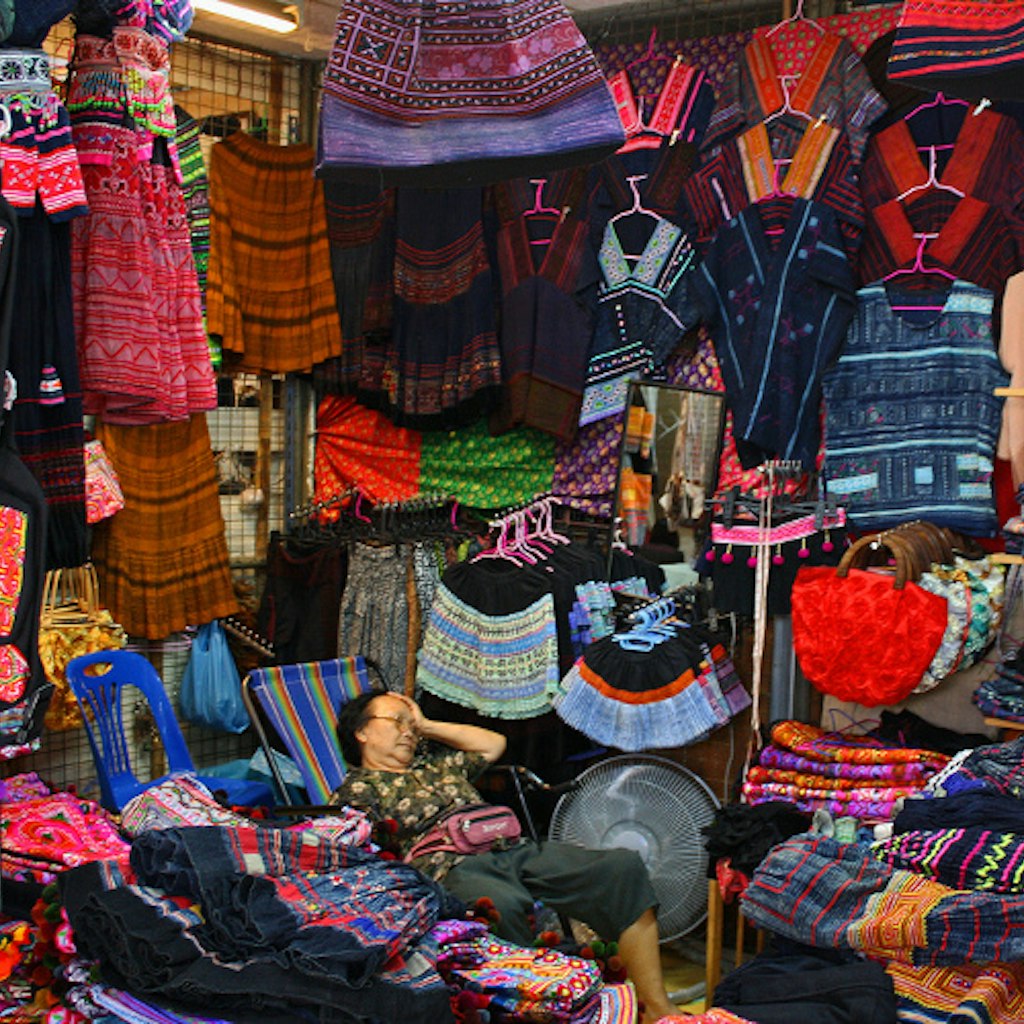 A clothing vendor enjoys a moment of respite at Chatuchak Weekend Market, Bangkok. Image by istolethetv CC BY 2.0