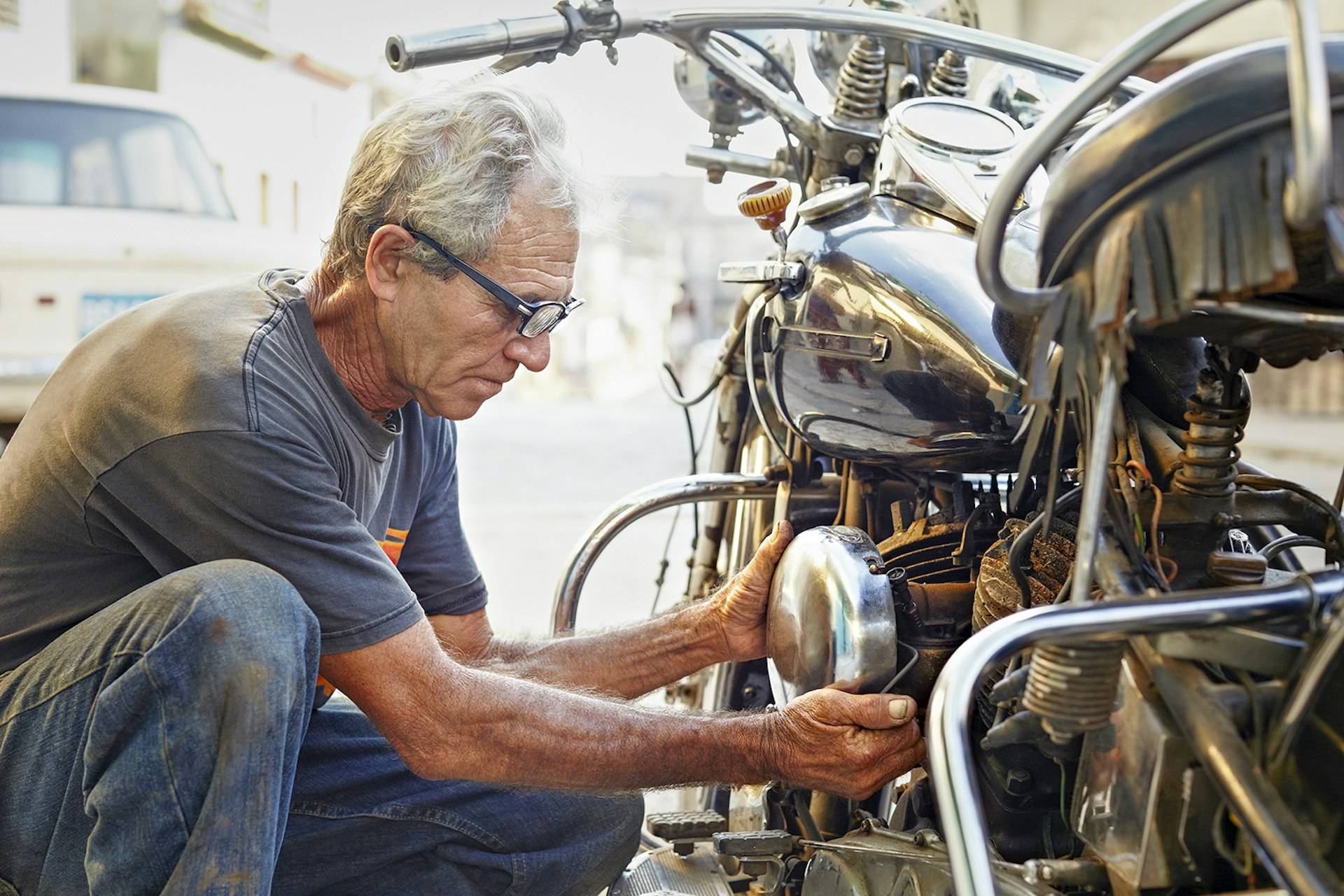 Features - Older man examining his motorcycle