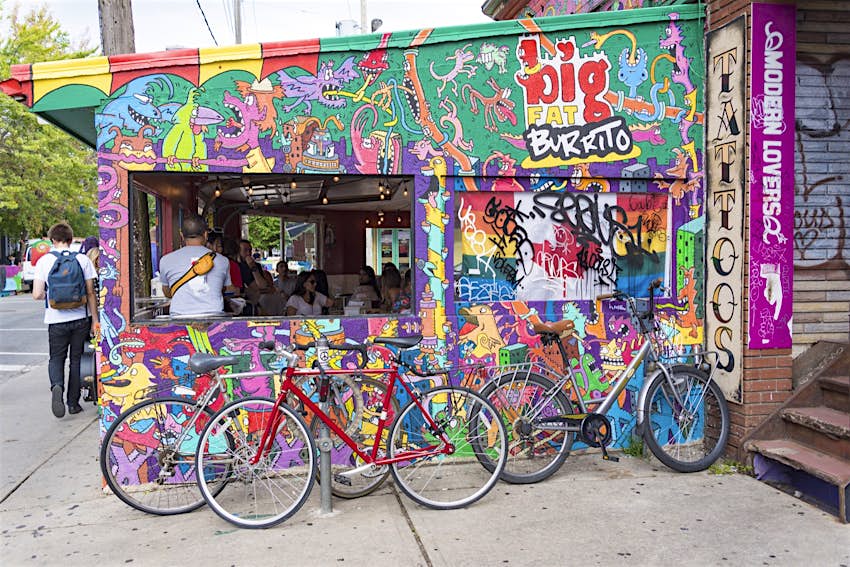 Bicycles parked beside big fat burrito outlet in Kensington Market, Toronto
