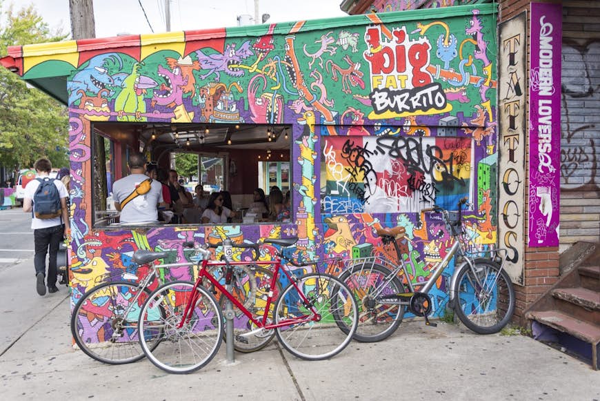 Bicycles parked beside big fat burrito outlet in Kensington Market, Toronto