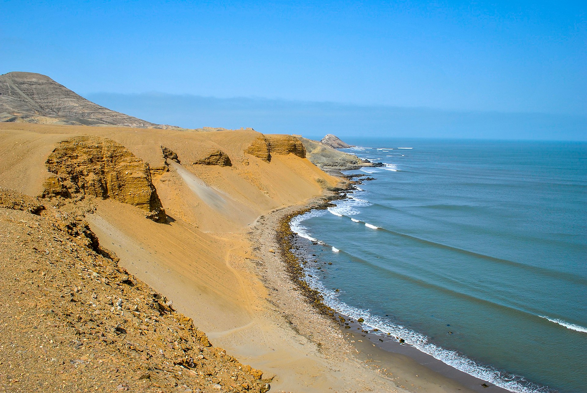 A coastline buttressed by large golden dunes and rock faces © marcosvelloso / shutterstock
