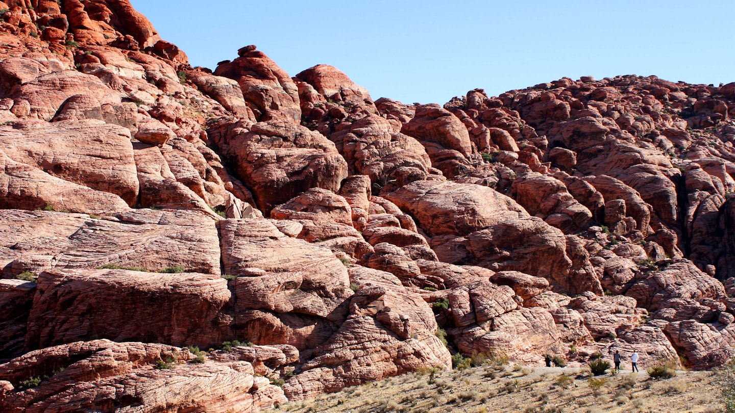 Hikers plan their route near rock formations in Red Rock Canyon. Image by Alexander Howard / Lonely Planet