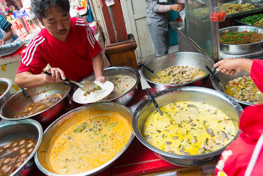 Dishing up curries at Ratana, a curry stall at Bangkok’s Nang Loeng Market. Image by Austin Bush