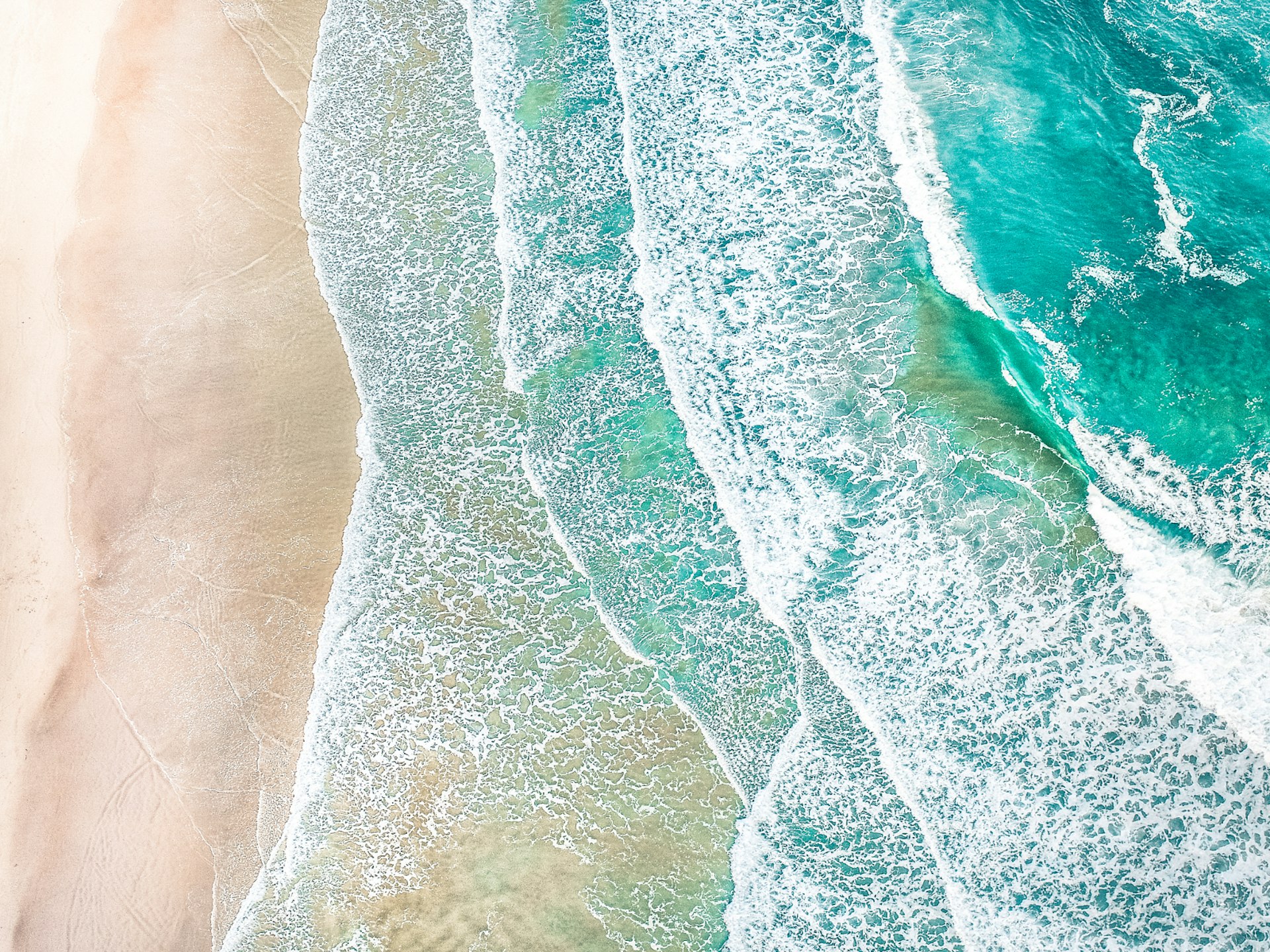 An aerial view of waves crashing on a beach
