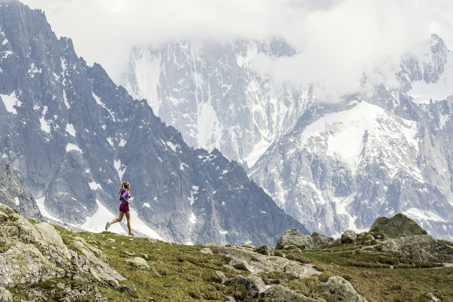 Girl trail running in Chamonix around the Chesery lake (Lac des Cheserys). In the background many mountains are visible. 