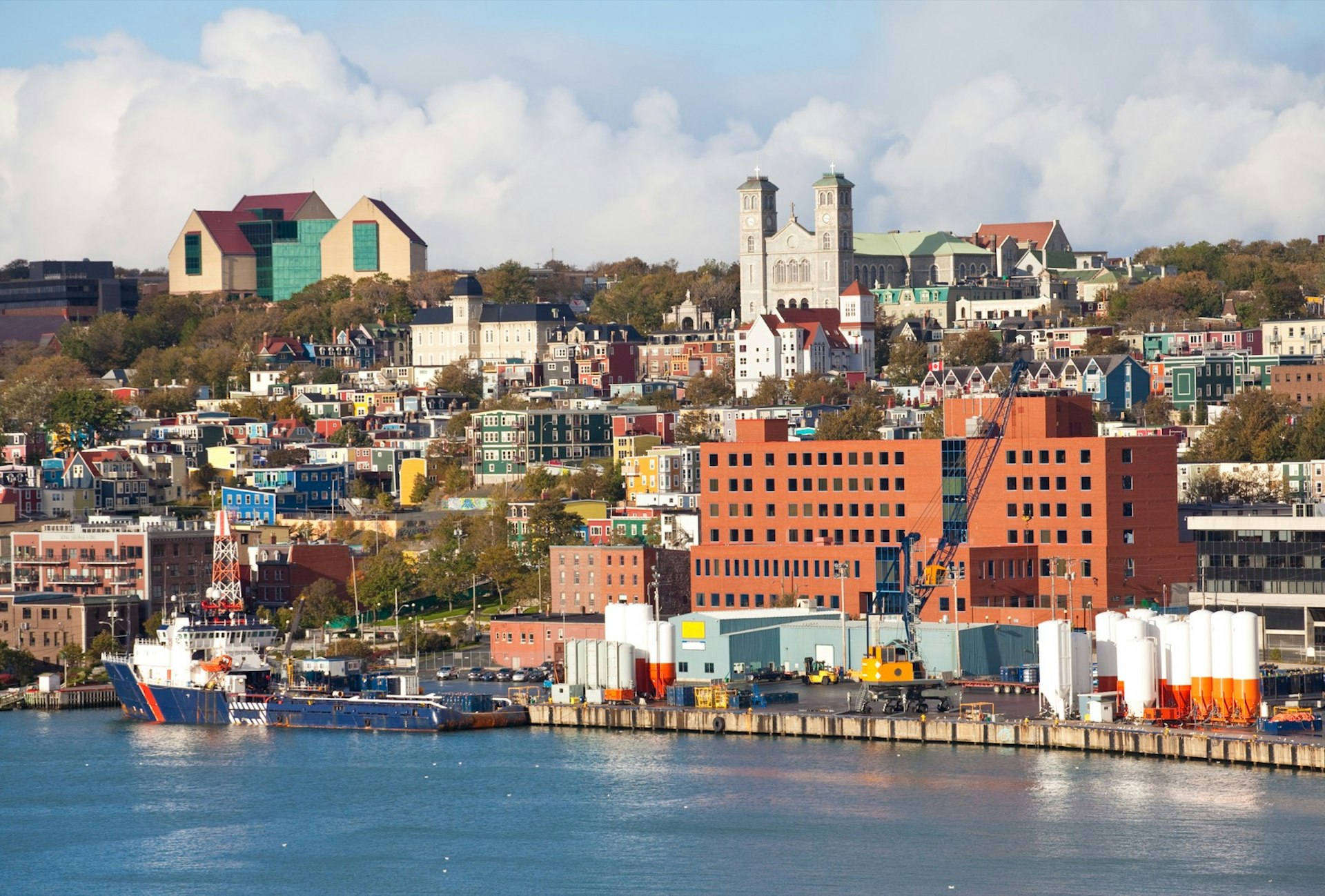 Colorful buildings mark the shore of St. John's Harbour in Newfoundland, Canada on a sunny day.