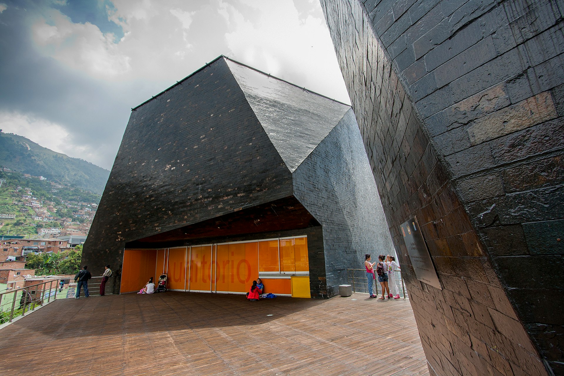 A hulking black monolith with patrons standing on a patio