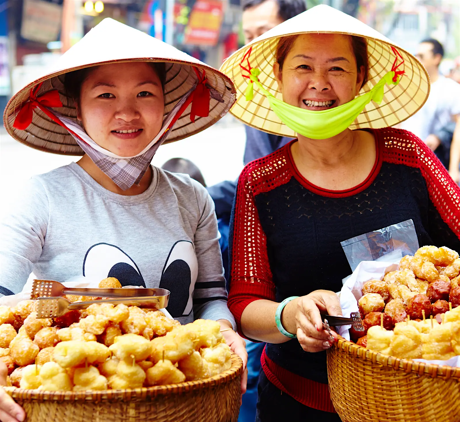 Features - Vietnam-people-da8599da070f Two women pose with baskets of street food in Hanoi. Both women are wearing conical hats, which are common in the country.