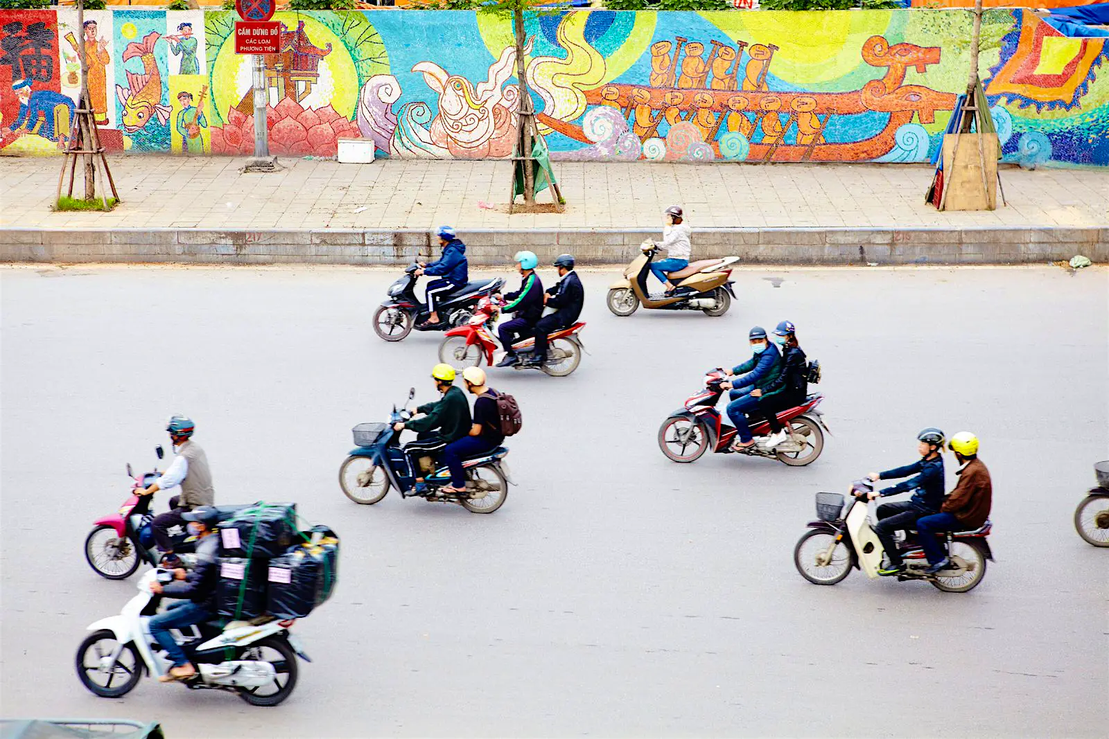 Features - Scooter traffic in streets of Hanoi. Aerial view of a selection of mopeds driving down a concrete street in Hanoi
