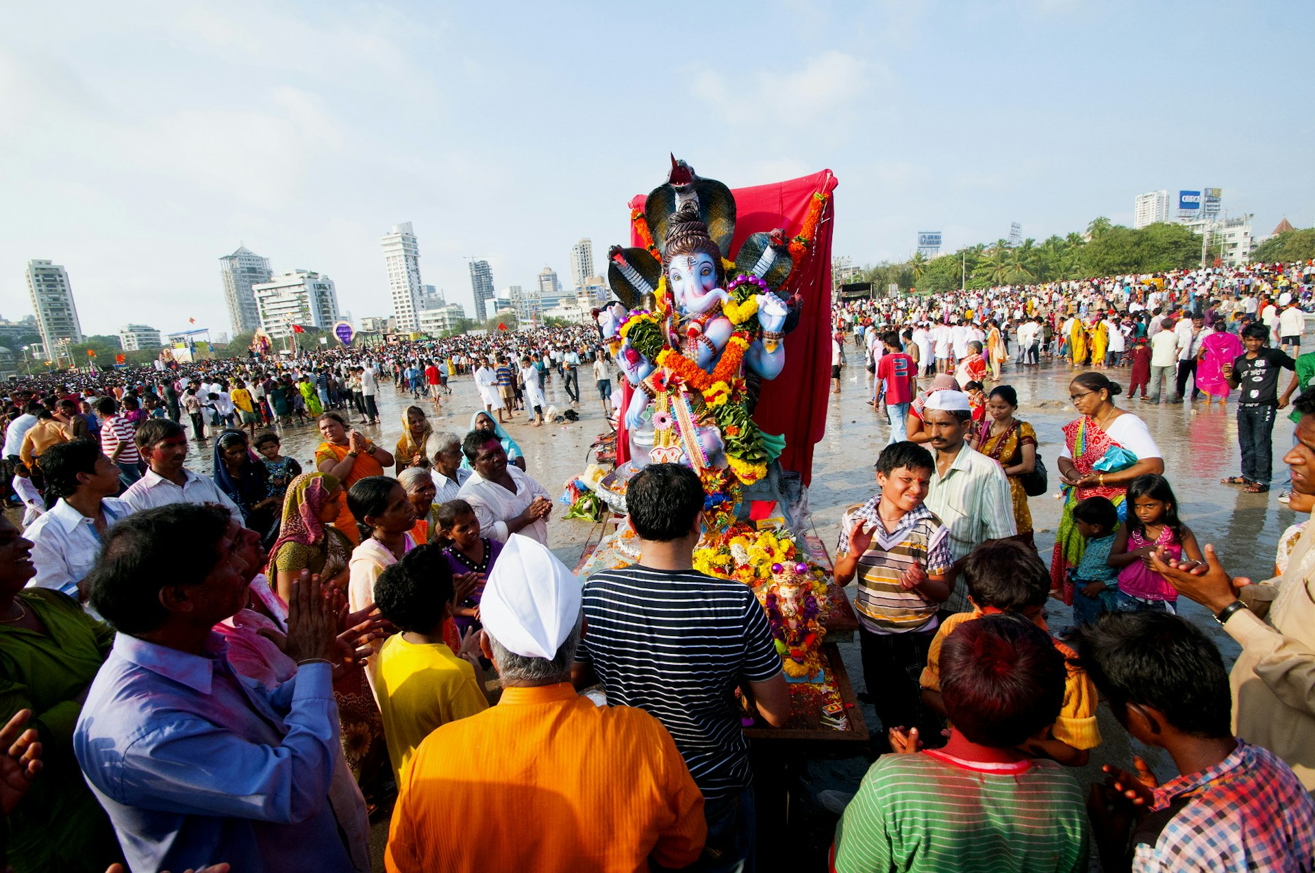 Devotees carry a rainbow-coloured statue of Ganesha down to the ocean © CRS PHOTO / Shutterstock Royalty Free