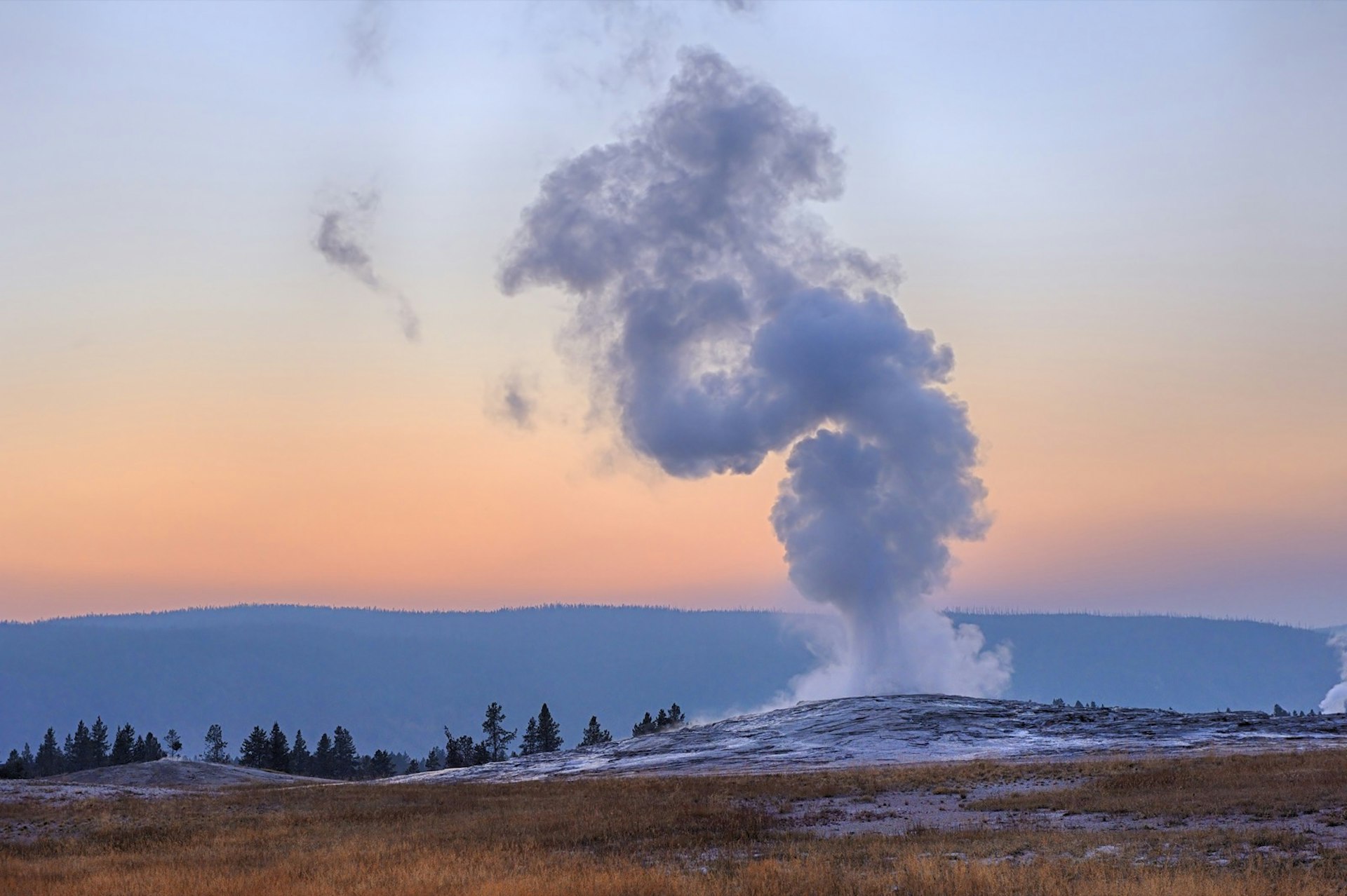 The Old Faithful Geyser at Yellowstone National Park erupts at sunset in Wyoming. It's one of several supersized natural wonders in the US National Parks system