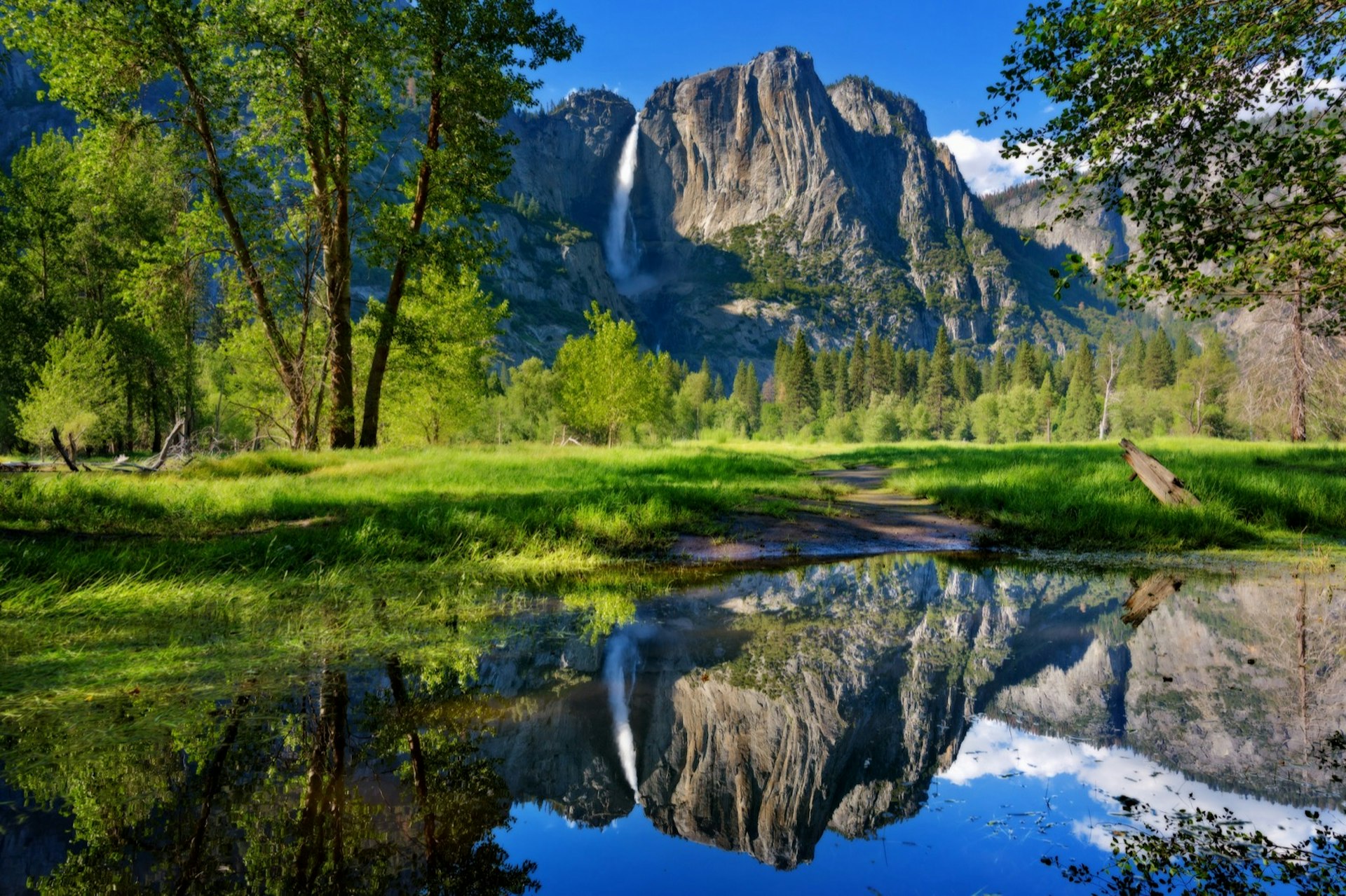 Yosemite Falls reflected perfectly in outlet of Merced River by Swinging Bridge, Yosemite National Park, California