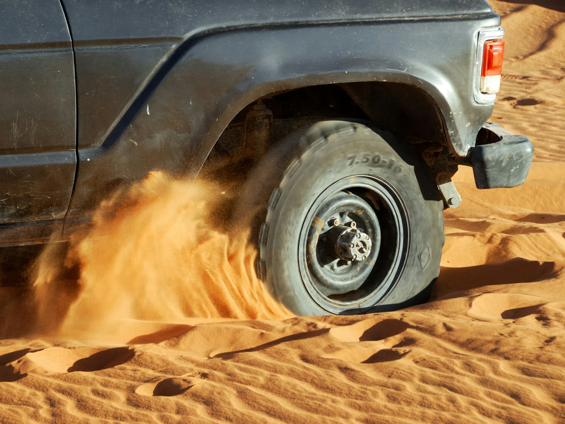 A car wheel stuck in desert sand © MrLis / Shutterstock