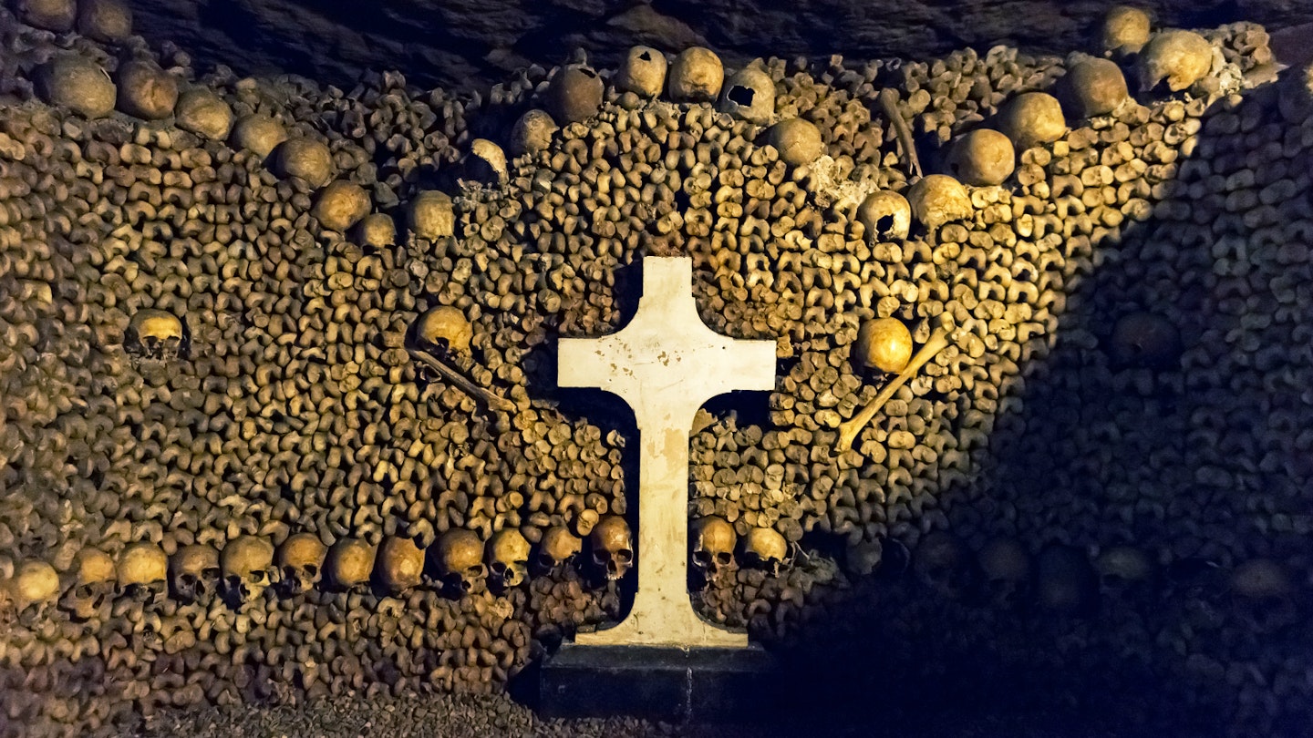 Skulls and a cross in Les Catacombes in Paris