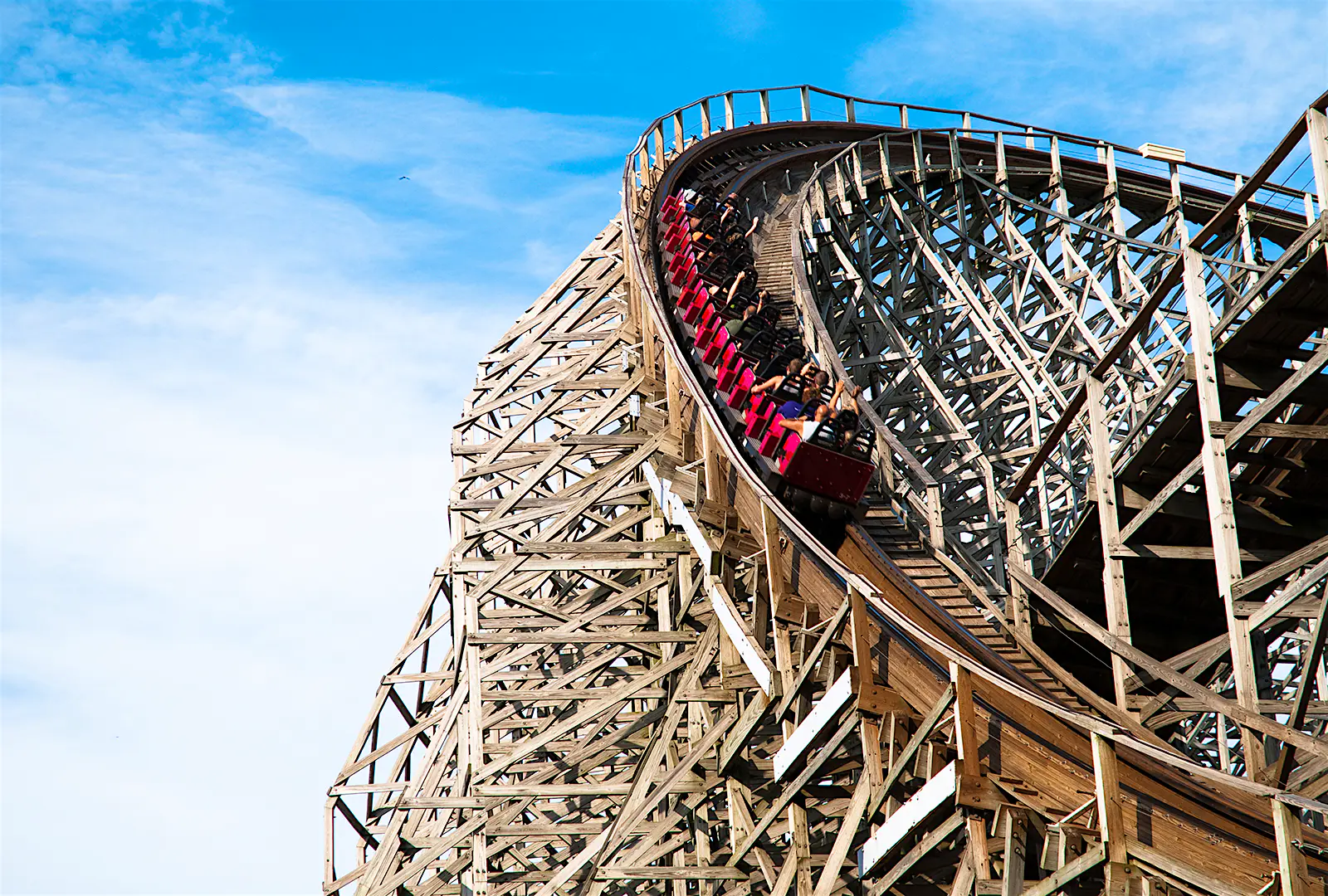 Features - Classic roller coaster with people at Cedar Point, Sandusky, Ohio People riding a classic wooden roller coaster at Cedar Point; North America's top amusement parks