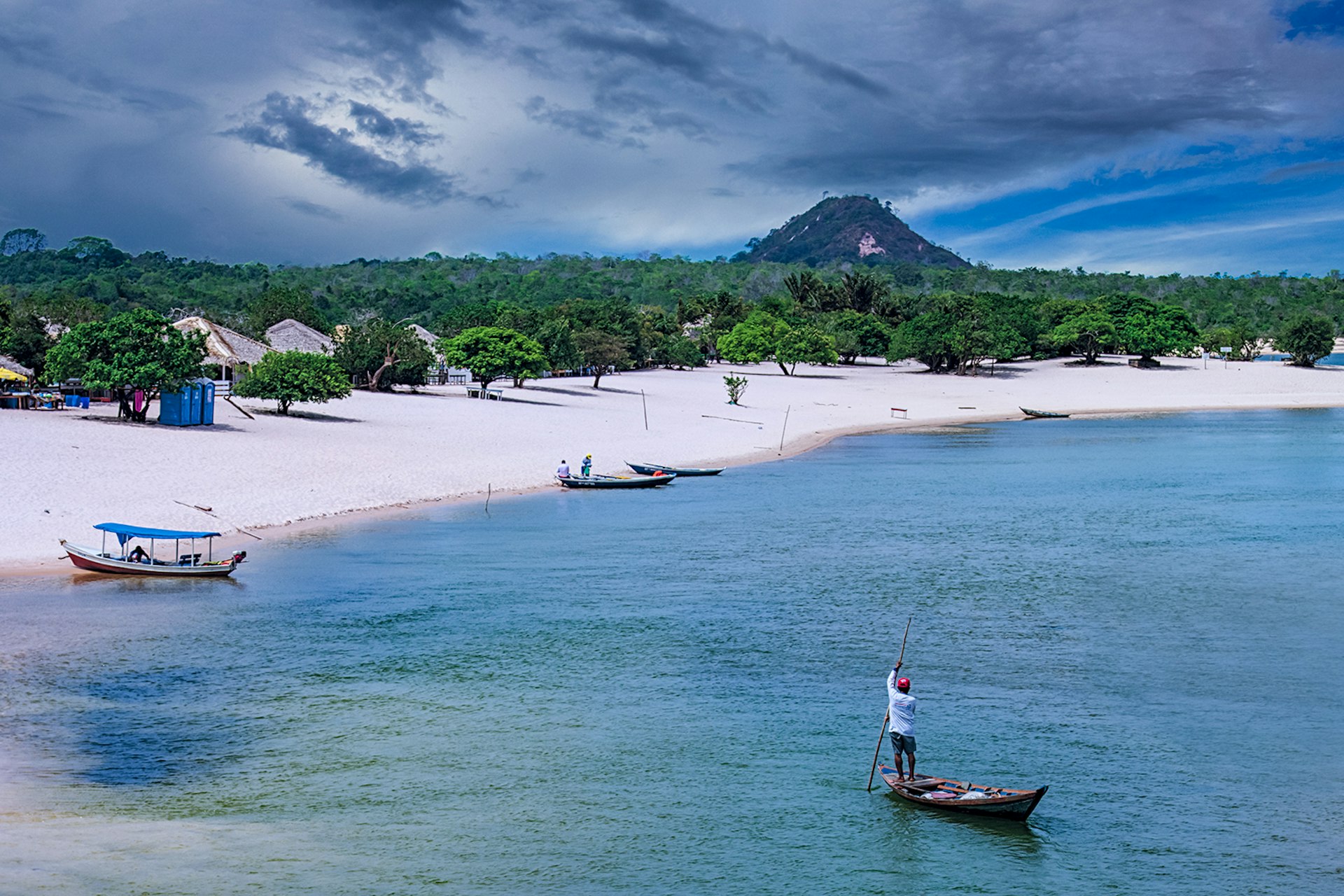 A view of a white-sand beach with the Amazon jungle in the background