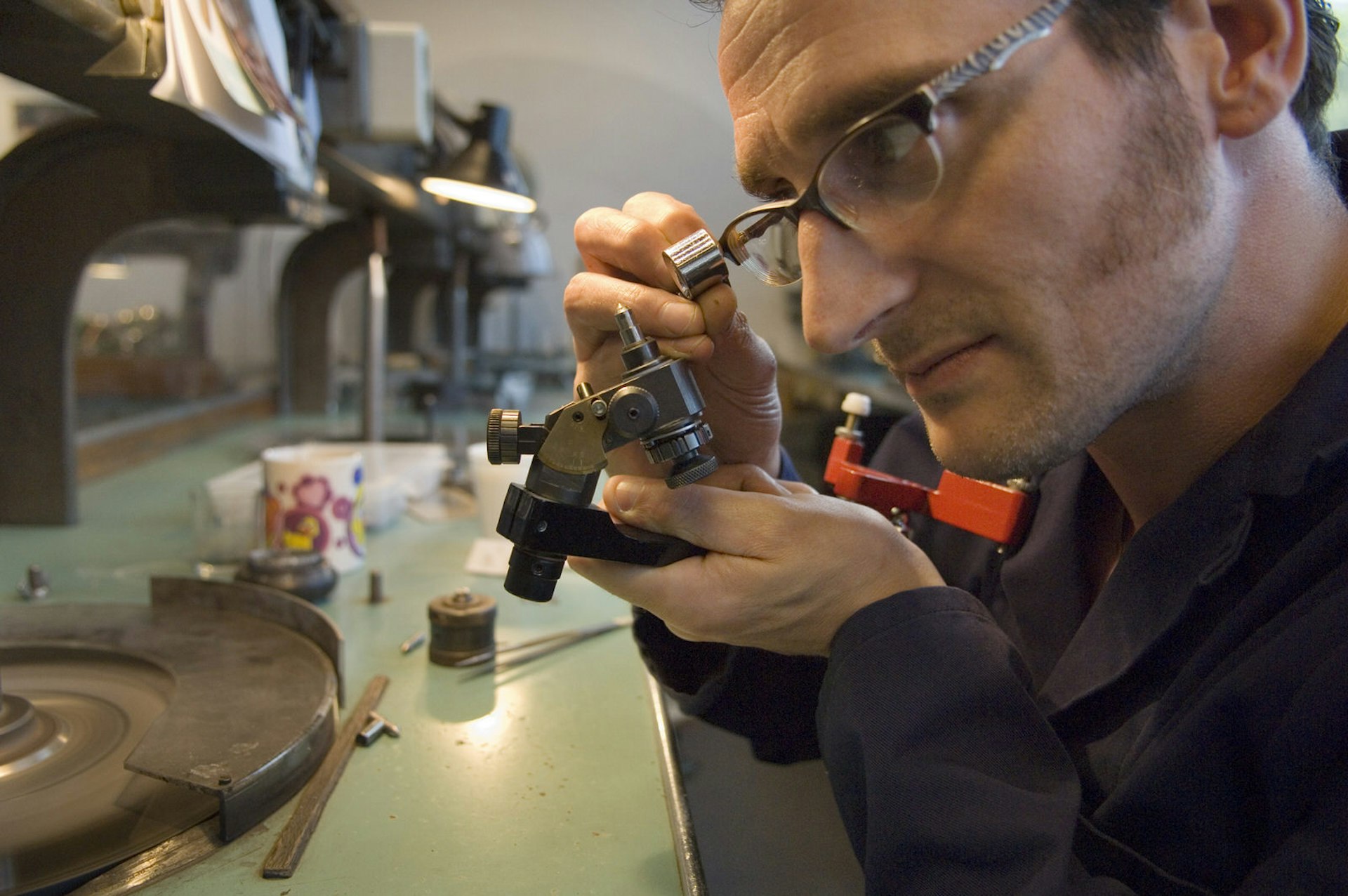 A male employee sharpens a diamond using a microscope on the Gassan Diamond Factory Tour, Amsterdam