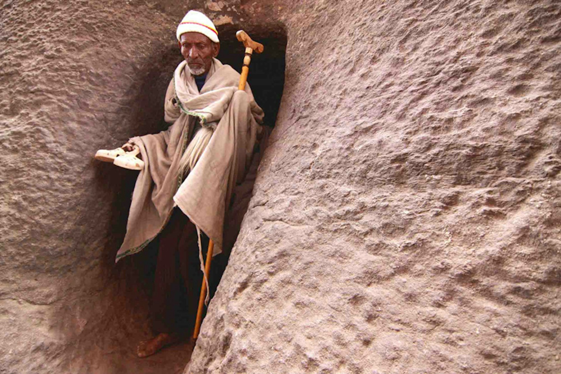 Home to a dozen or so rock-hewn churches linked by tunnels and passageways Lalibela, or the new Jerusalem, is a site of great religious significance to Ethiopian Christians. Here a pilgrim emerges from a tunnel into the courtyard of a church. Image by Stuart Butler / Lonely Planet.