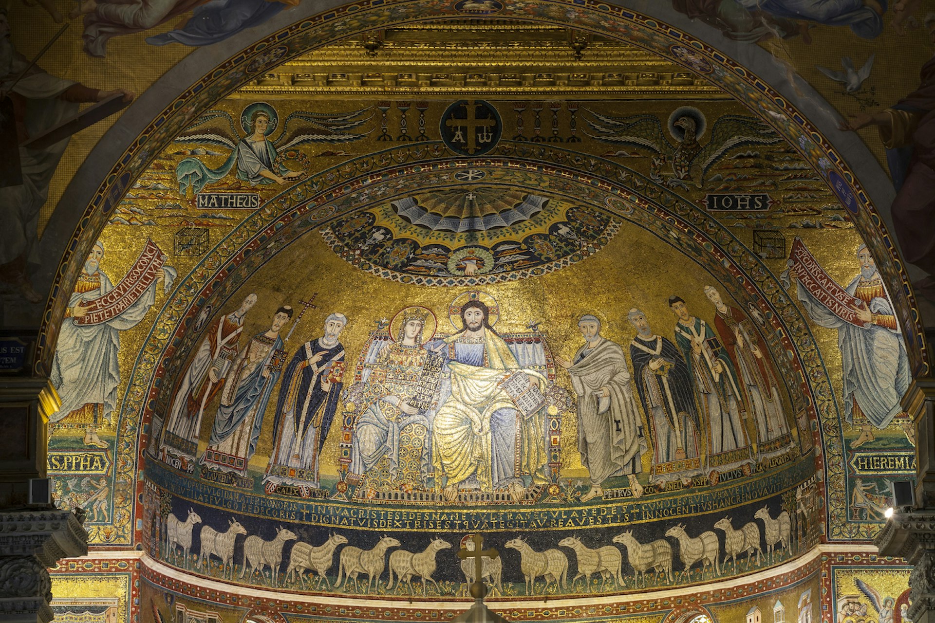 A golden mural depicting Jesus and his disciples is illuminated inside Basilica di Santa Maria in the Trastevere neighborhood of Rome