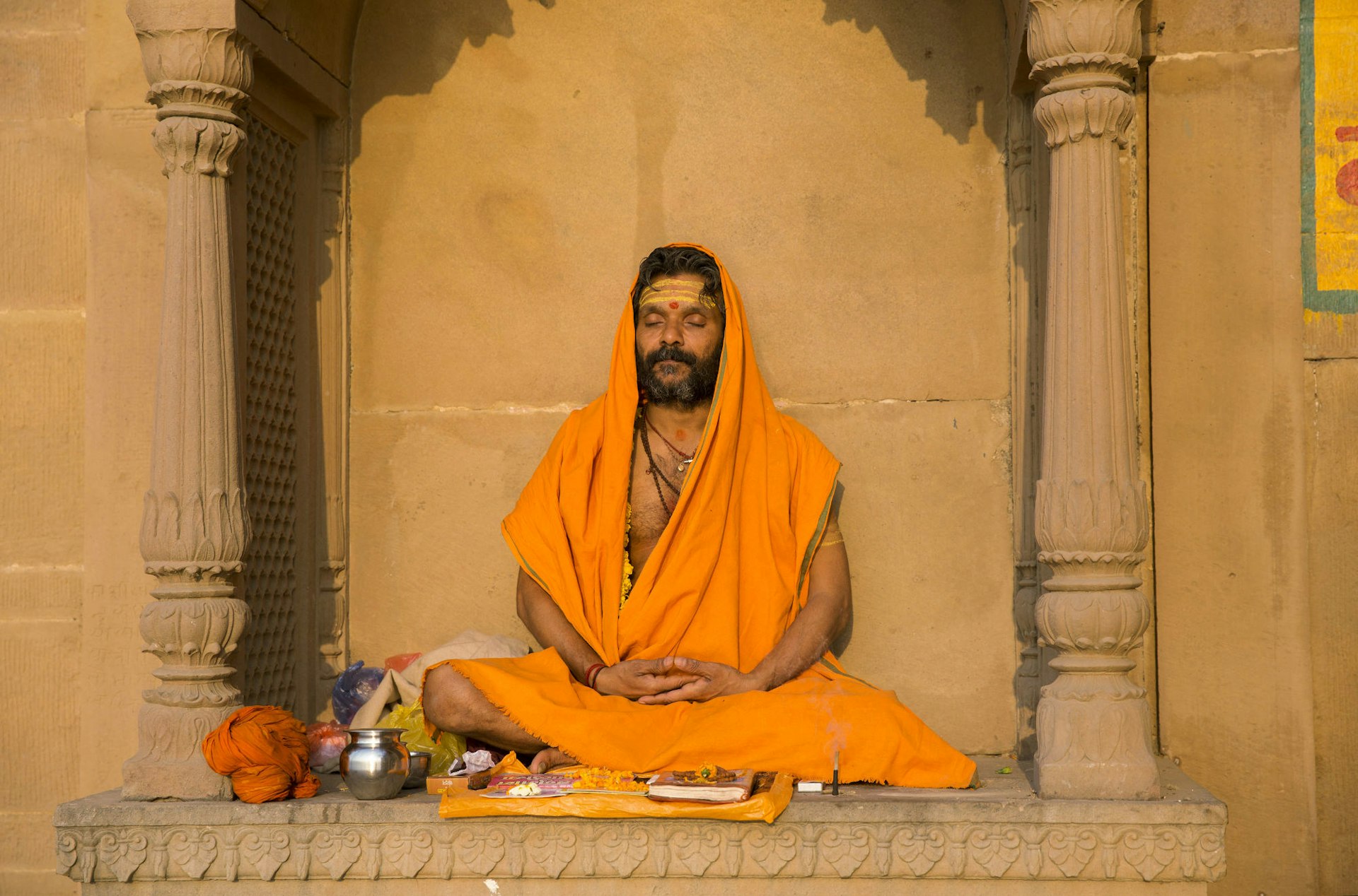A sadhu (holy man) mediates in the warm sunshine